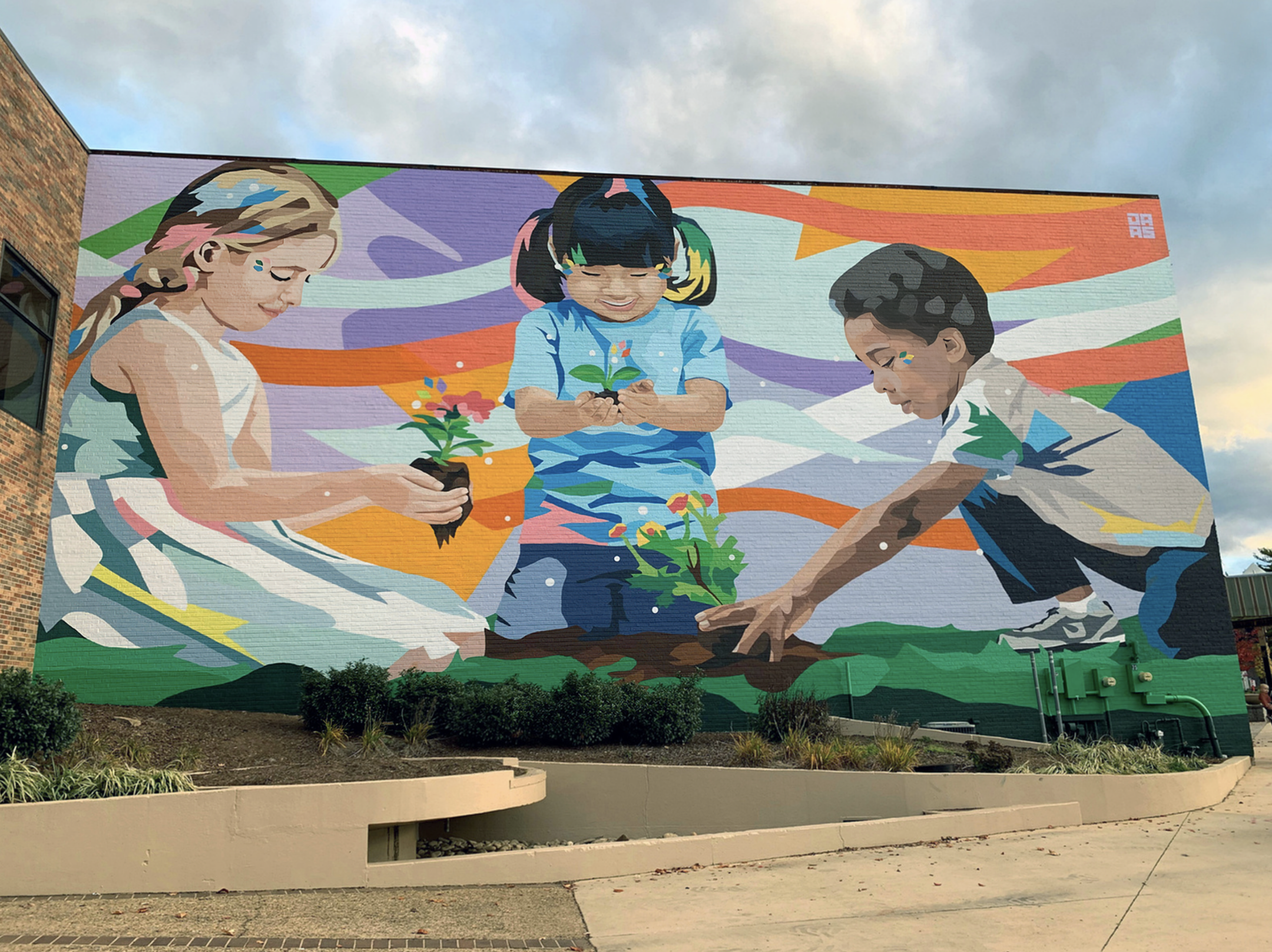 Work by the artist DAAS, Colorful mural of three children planting flowers.