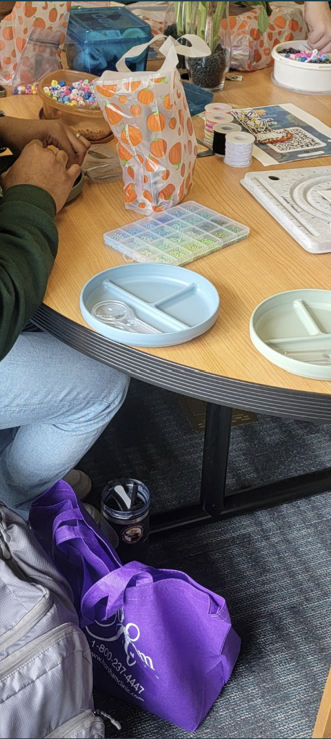 People making bracelets with beads.