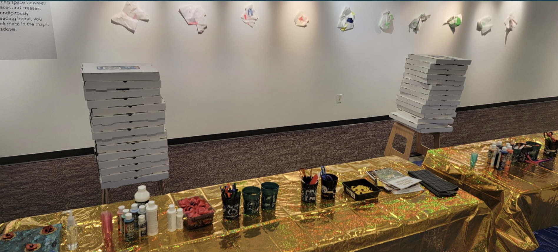 A table with paint and a stack of pizza boxes