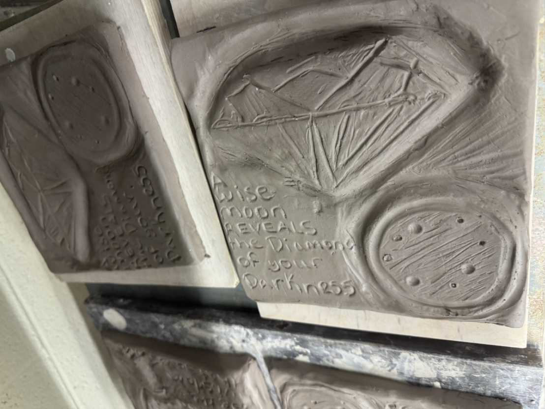 Clay tile engraving of a diamond and a moon