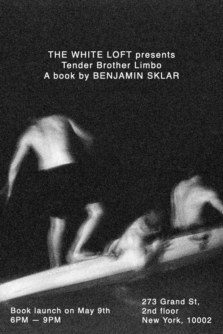 Black and white photo of two people performing gymnastics on a balance beam, with one person standing and the other lying.
