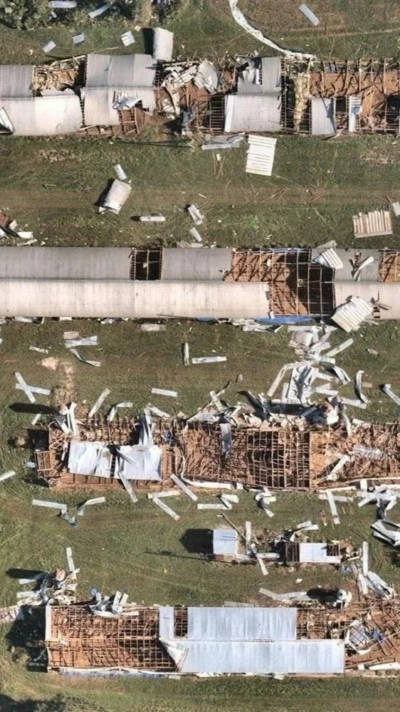Aerial drone view of destroyed buildings with collapsed roofs, scattered debris, and damaged fixtures, caused by a natural disaster for searching and insurance purposes by DeepSky IQ