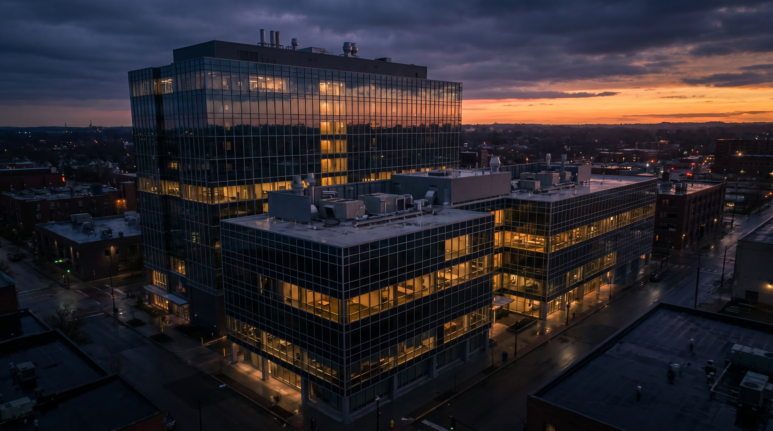 A cityscape at dusk featuring a modern glass office building as an example for drone inspection by DeepSky IQ.