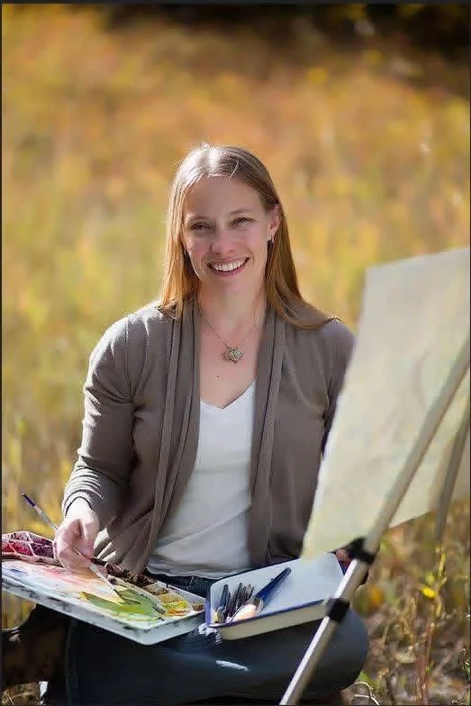Coral painting outdoors at an easel.