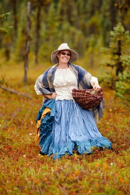 Coral outdoors holding a woven basket.