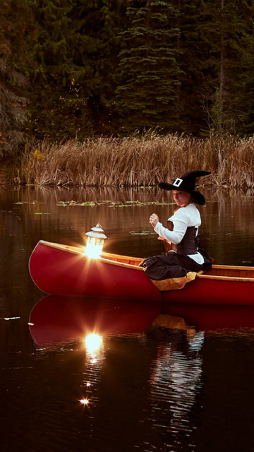 Coral in a red canoe on a sunlit lake.