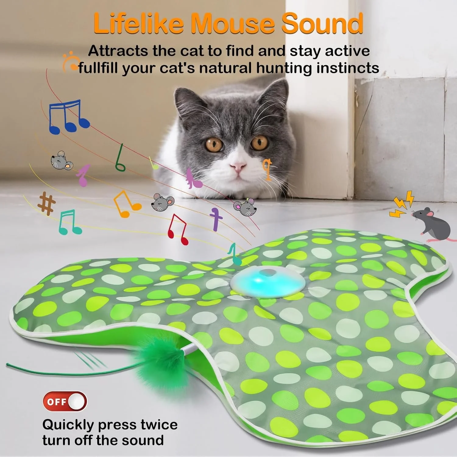 A cat with gray and white fur is lying on the floor behind a green, polka-dotted electronic mouse toy that has a blue light and a feathered tail. The toy makes mouse sounds and has colorful musical notes and mouse icons above it, indicating sounds. There is a switch on the lower left corner to turn the sound off or on, with instructions to press twice to turn off.