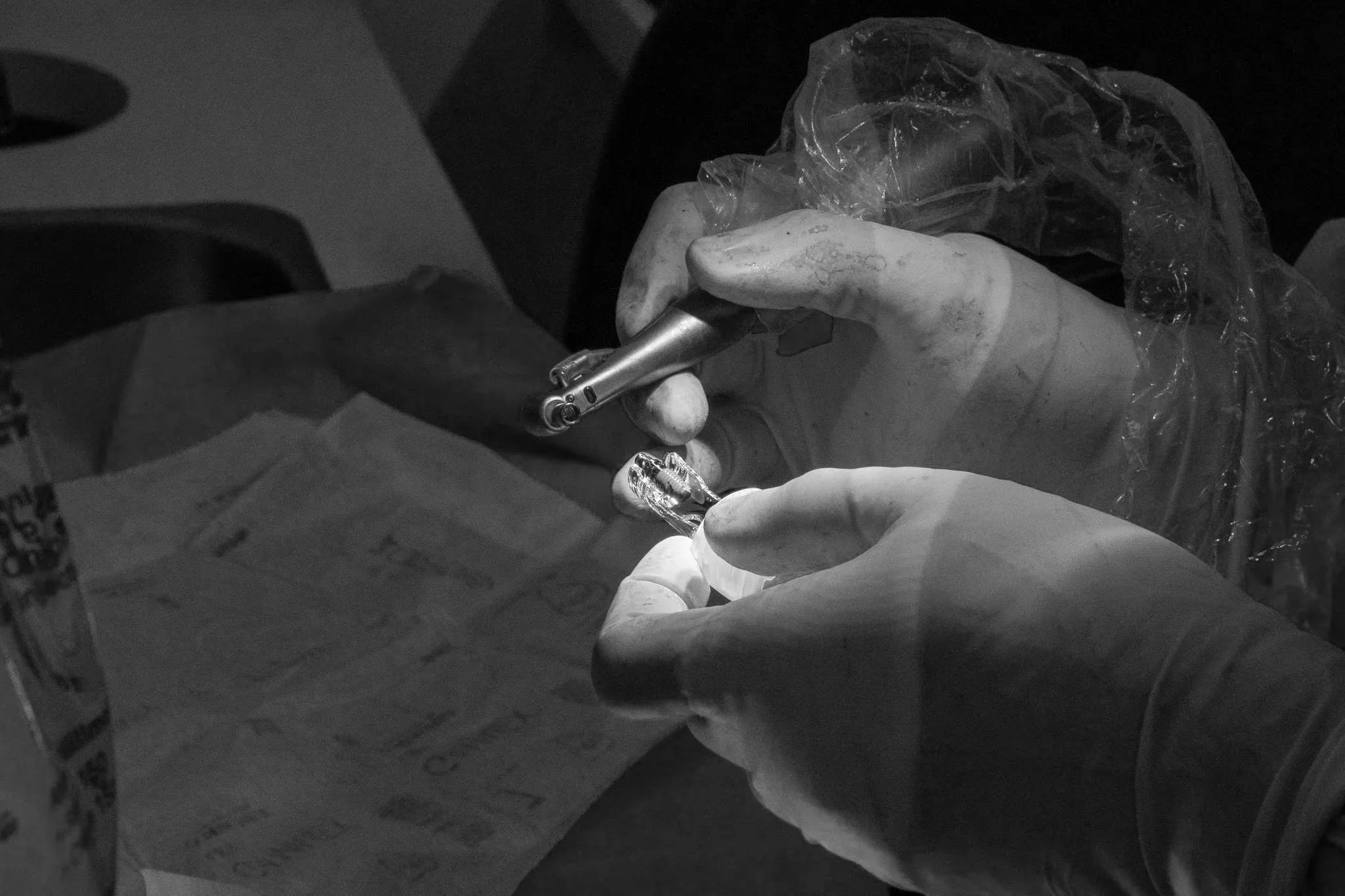 Close-up of a medical professional wearing blue gloves analyzing dental and medical scans on a tablet device.