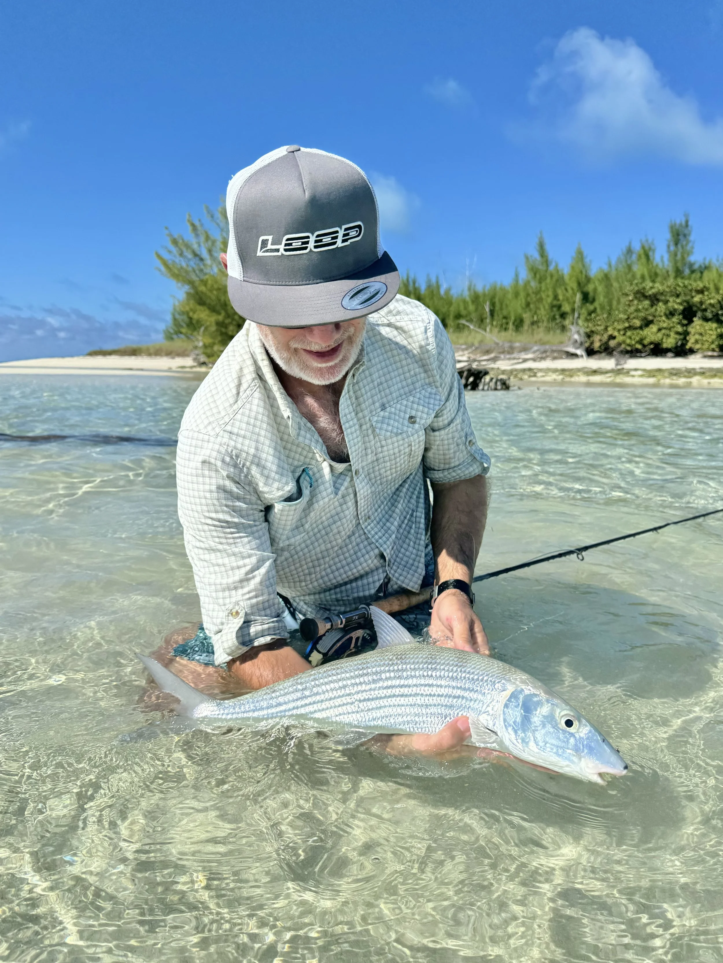 Angler releasing a bonefish while fishing the shallow flats of Grand Bahama, Bahamas.