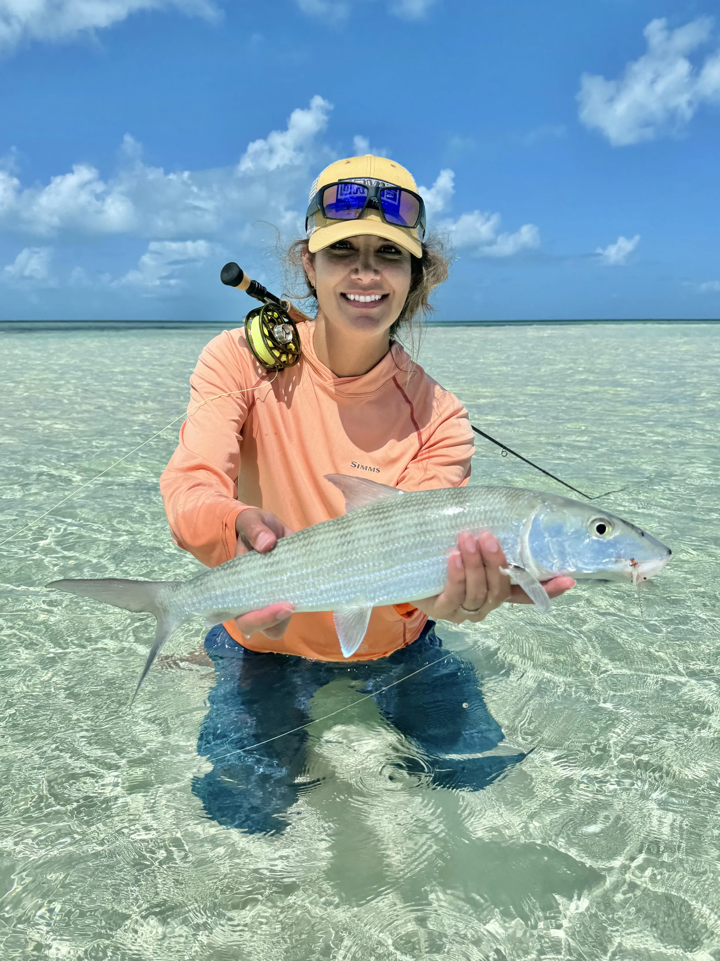 Guest holding a bonefish during a guided flats fishing trip in Grand Bahama, Bahamas.