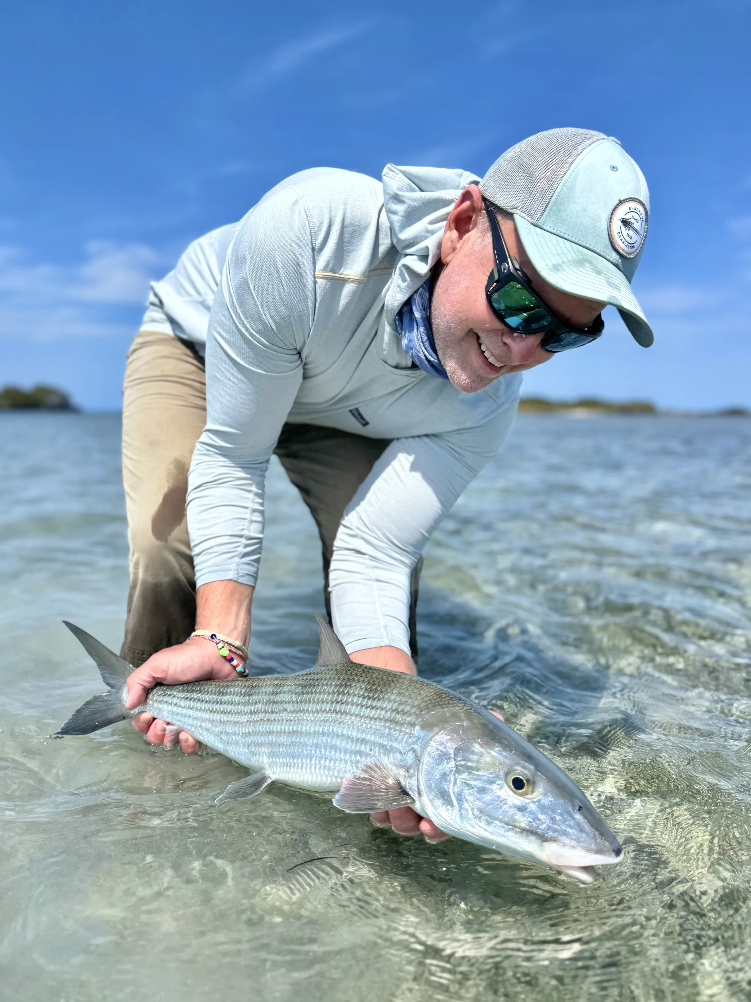 Angler releasing a large bonefish in the shallow flats of Grand Bahama, Bahamas.