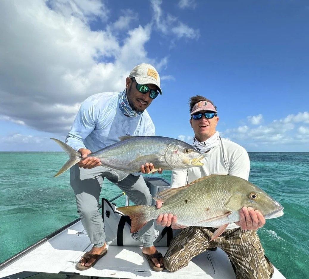 Captain Justin Lewis and his angler holding large yellow jack and mutton snapper caught in the waters of Grand Bahama, Bahamas.