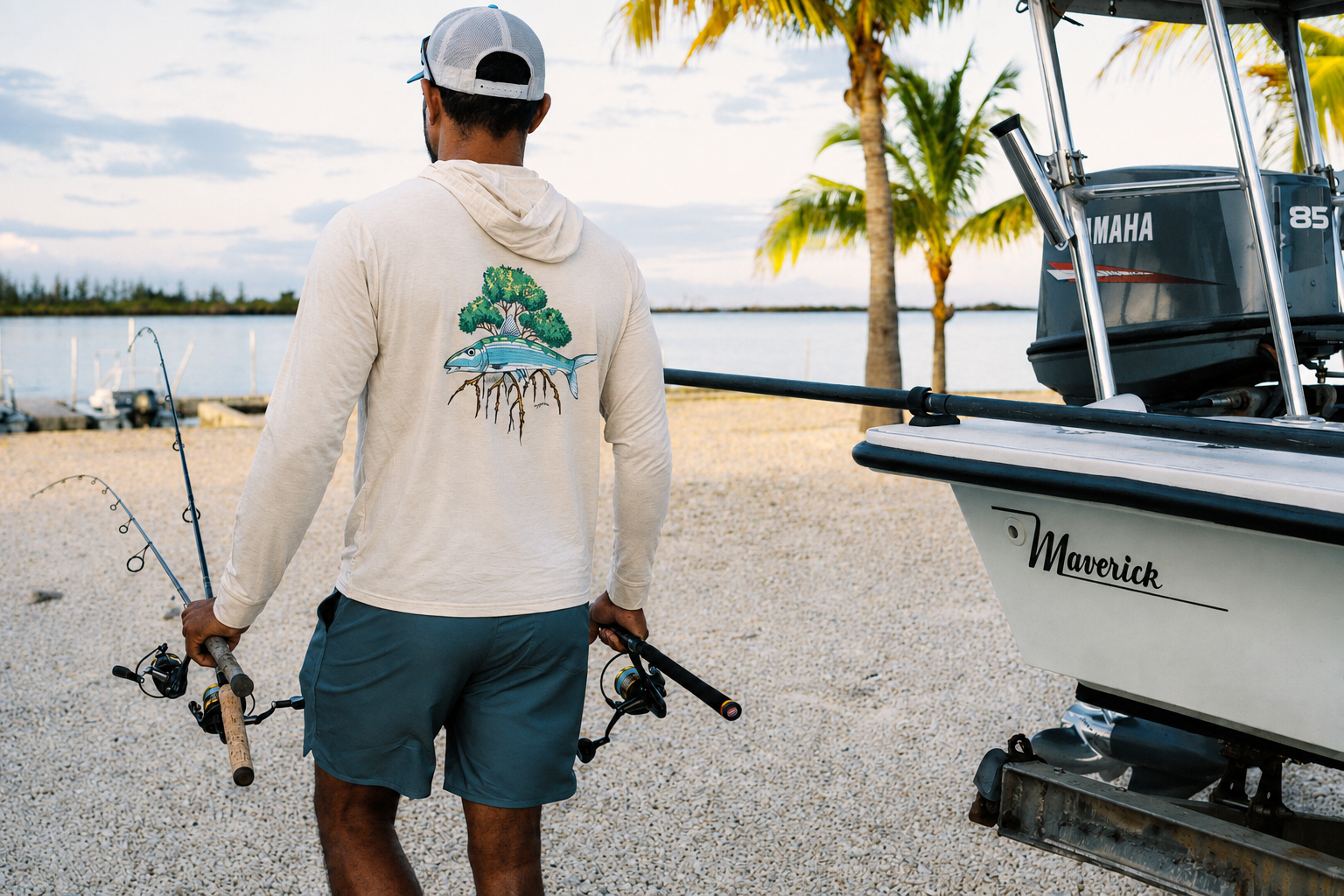 Guide carrying spinning rods beside a Maverick flats skiff, highlighting fishing equipment provided by Goombay Outfitters in Grand Bahama.