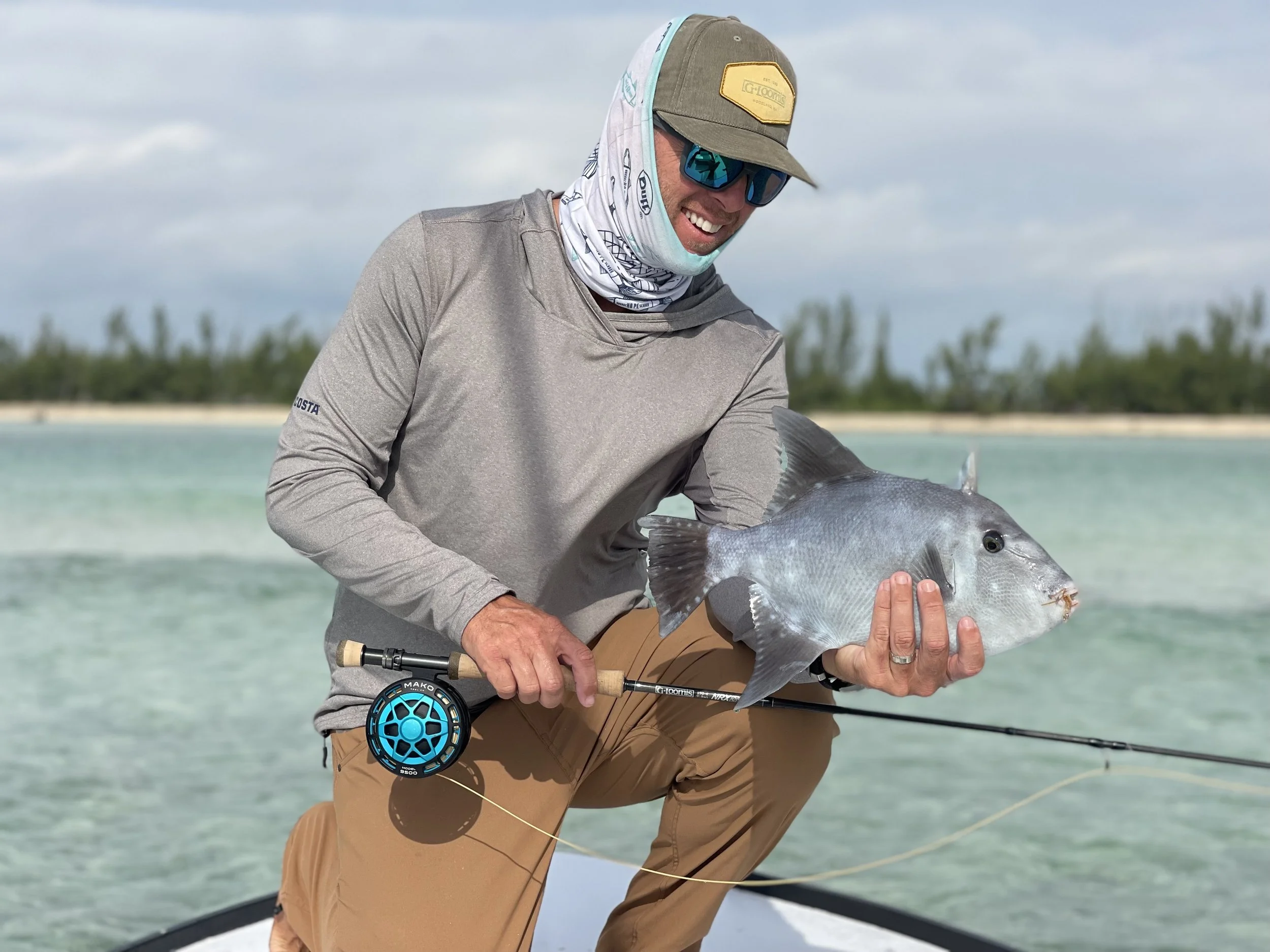Angler holding a triggerfish during a fly fishing trip in Grand Bahama, Bahamas.