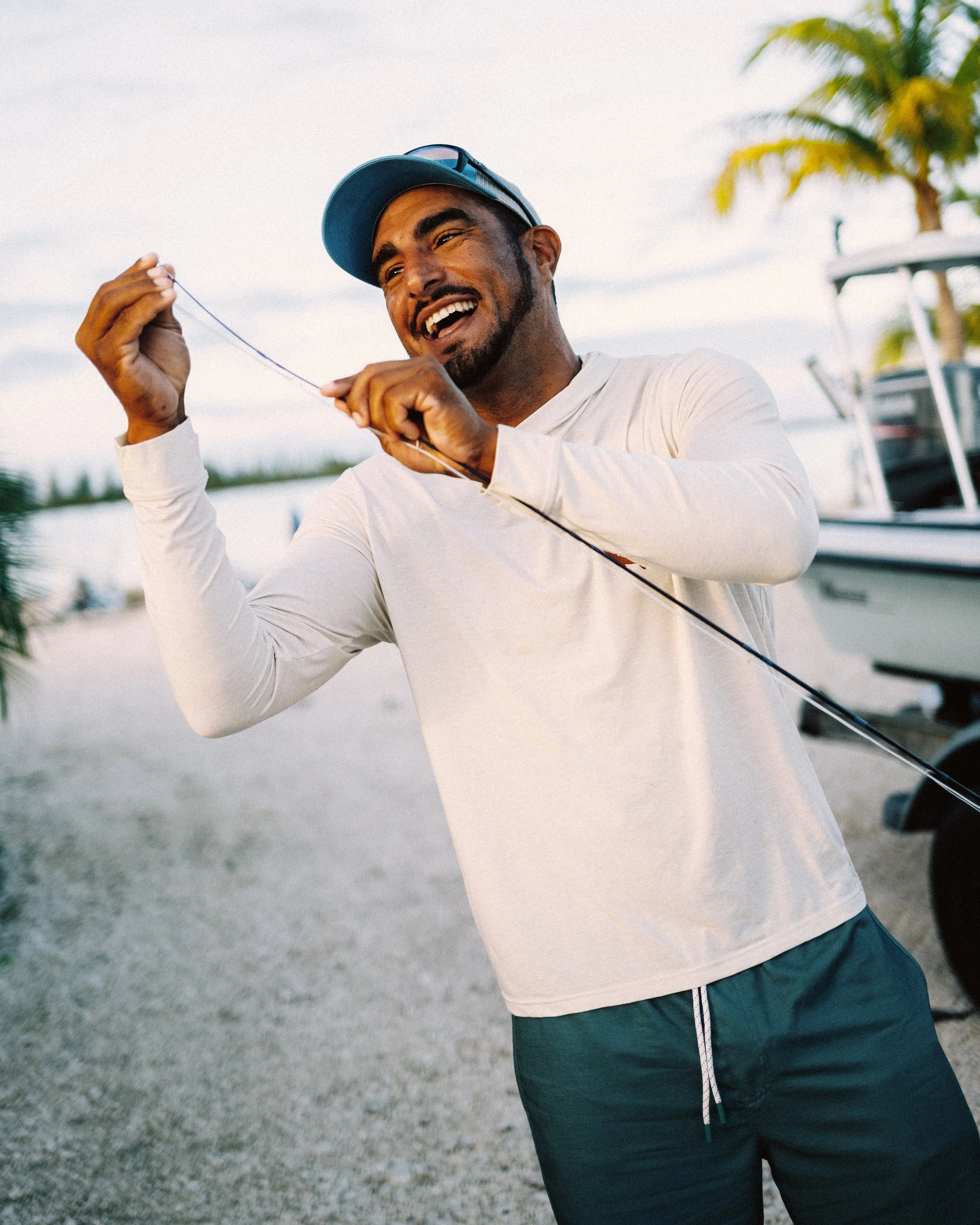 Guide Justin Lewis preparing fishing tackle beside his flats skiff preparing for a guided trip in Grand Bahama.