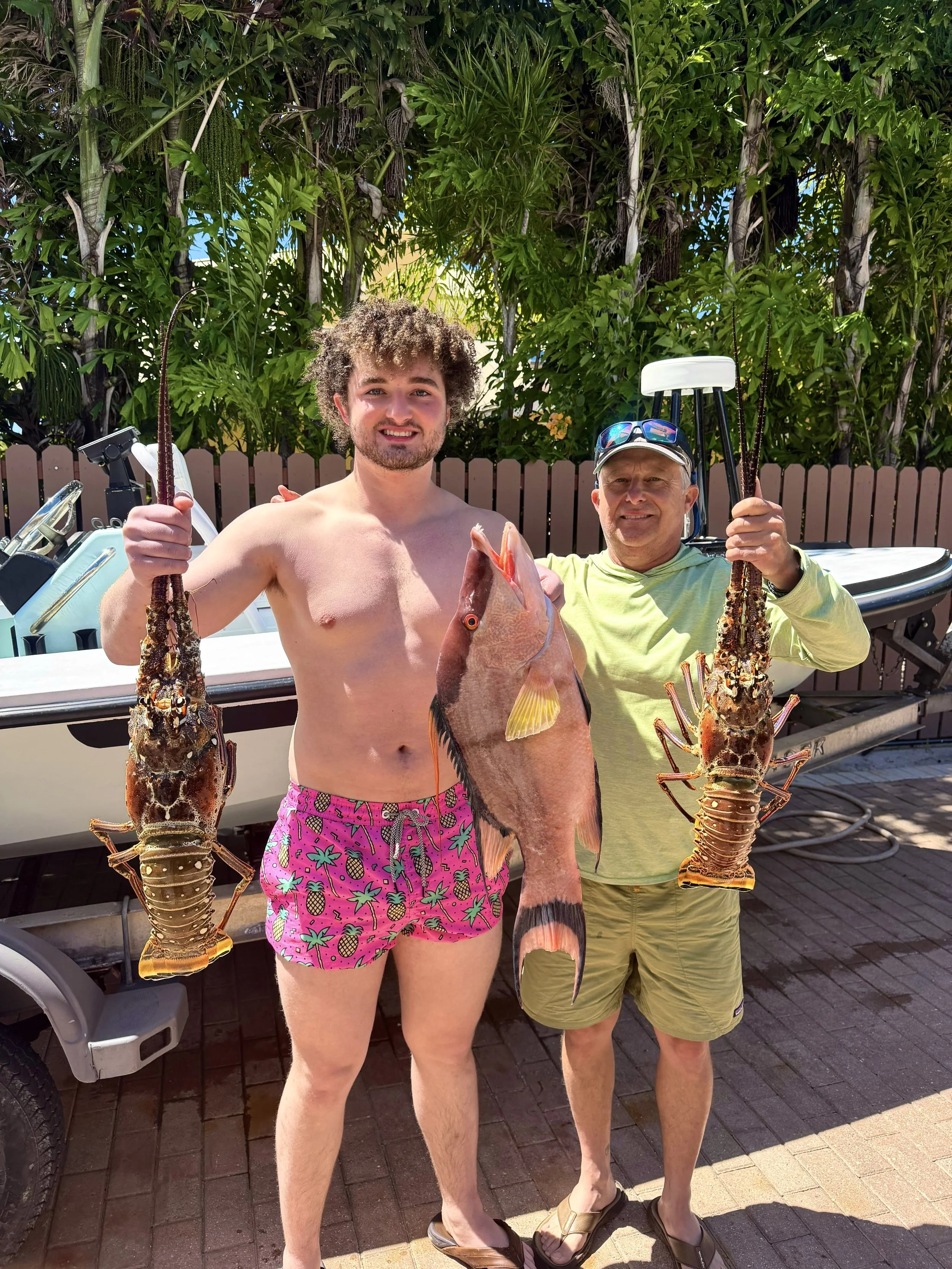 Spearfishers showing off catch of lobster and hogfish harvested in Grand Bahama, Bahamas.