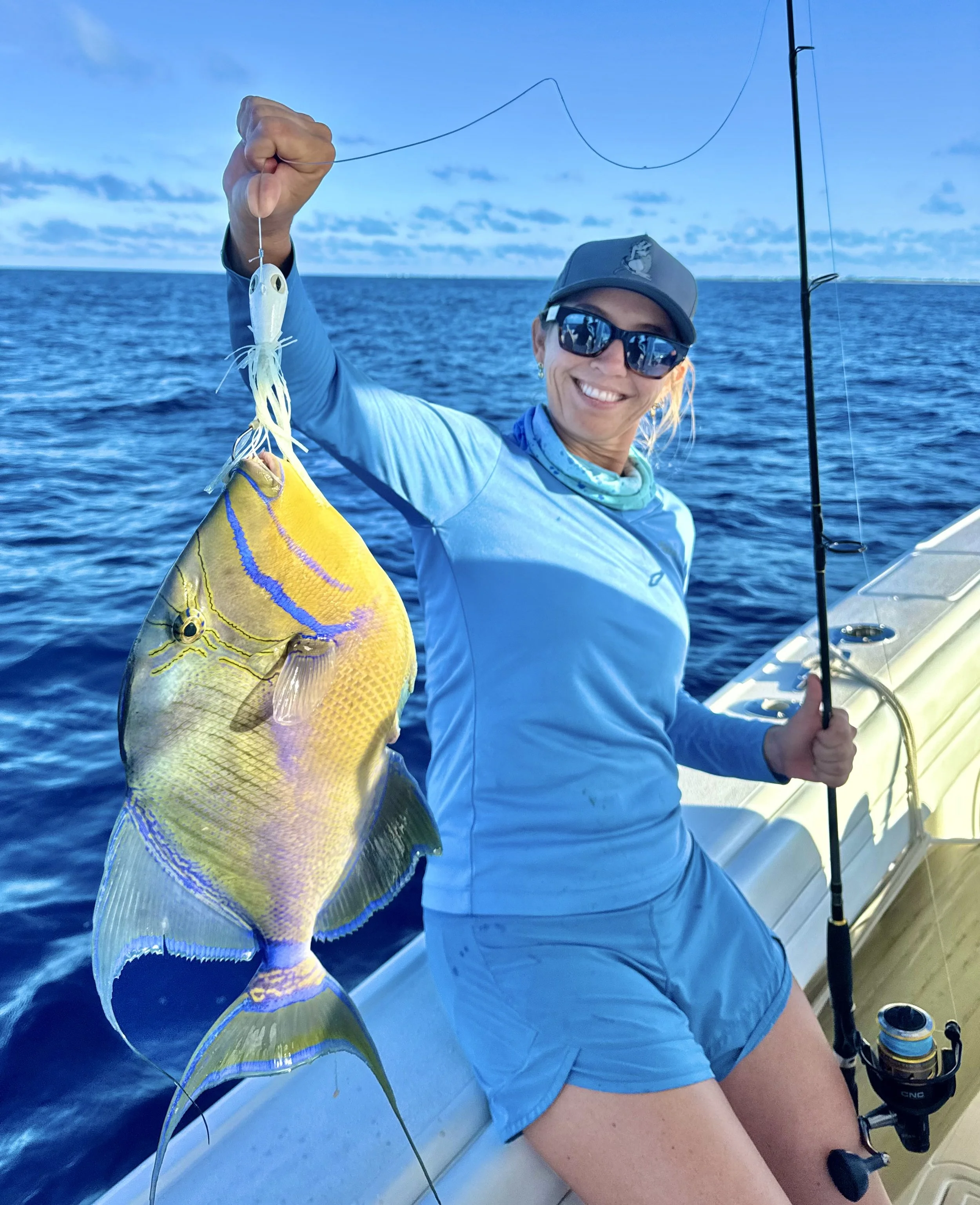 Angler holding a queen triggerfish caught while reef fishing in Grand Bahama, Bahamas.