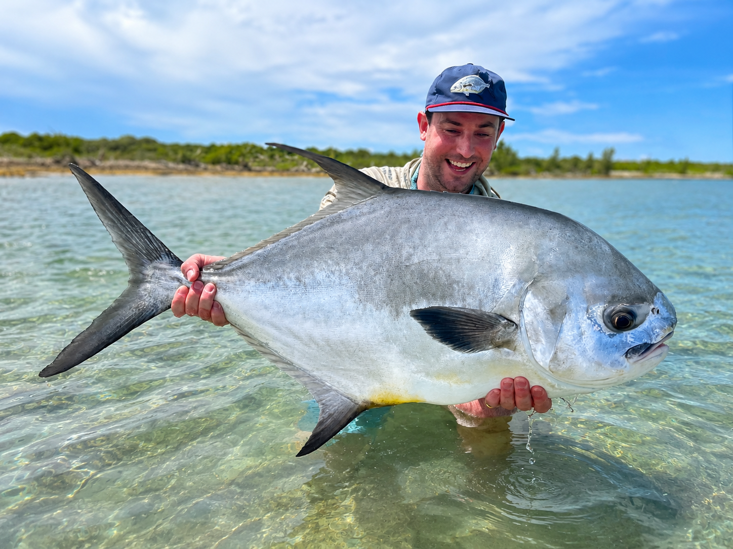 Angler holding a permit caught while flats fishing in Grand Bahama, Bahamas.