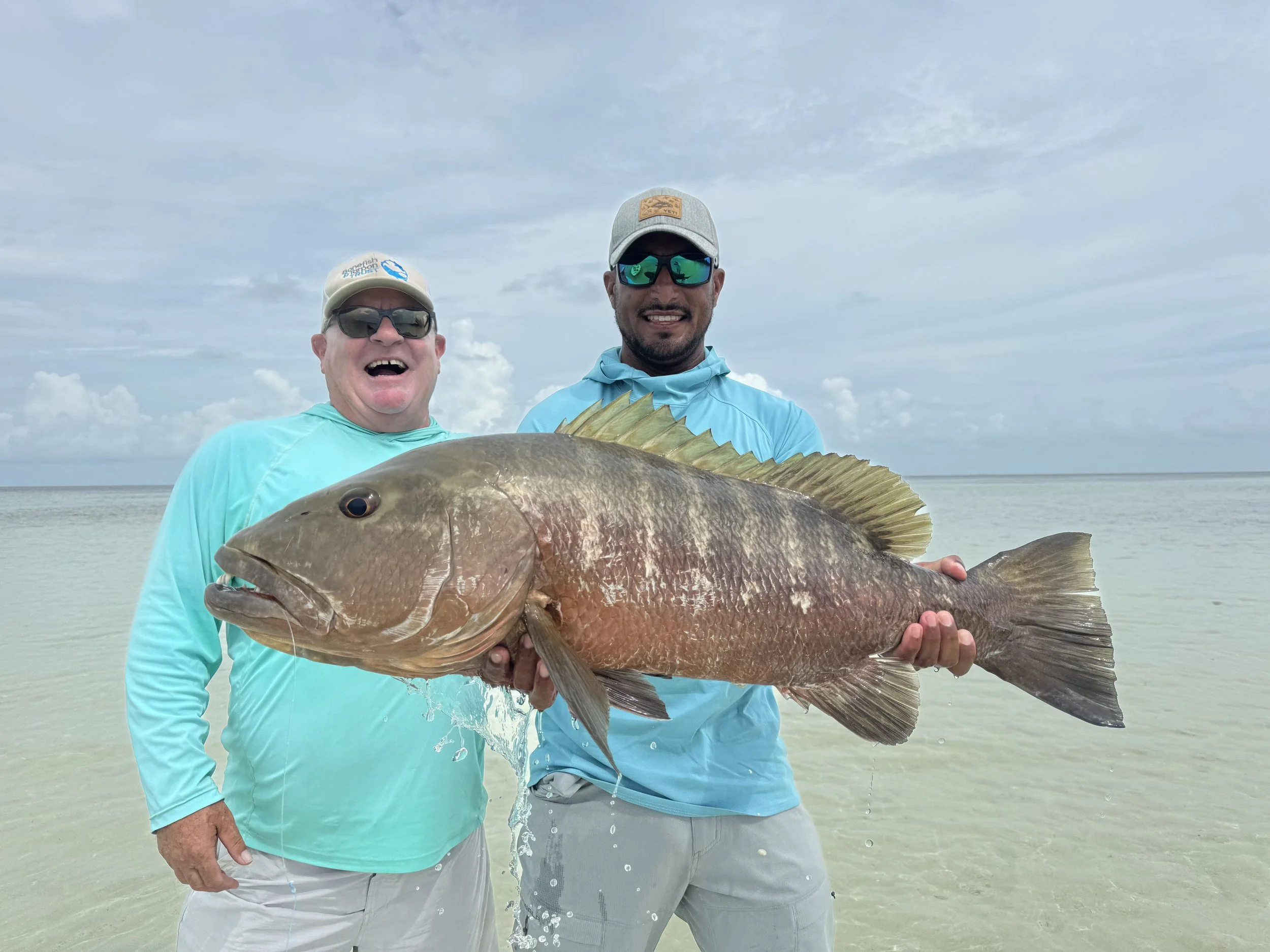 Guide and angler holding a trophy cubera snapper in Grand Bahama, Bahamas.