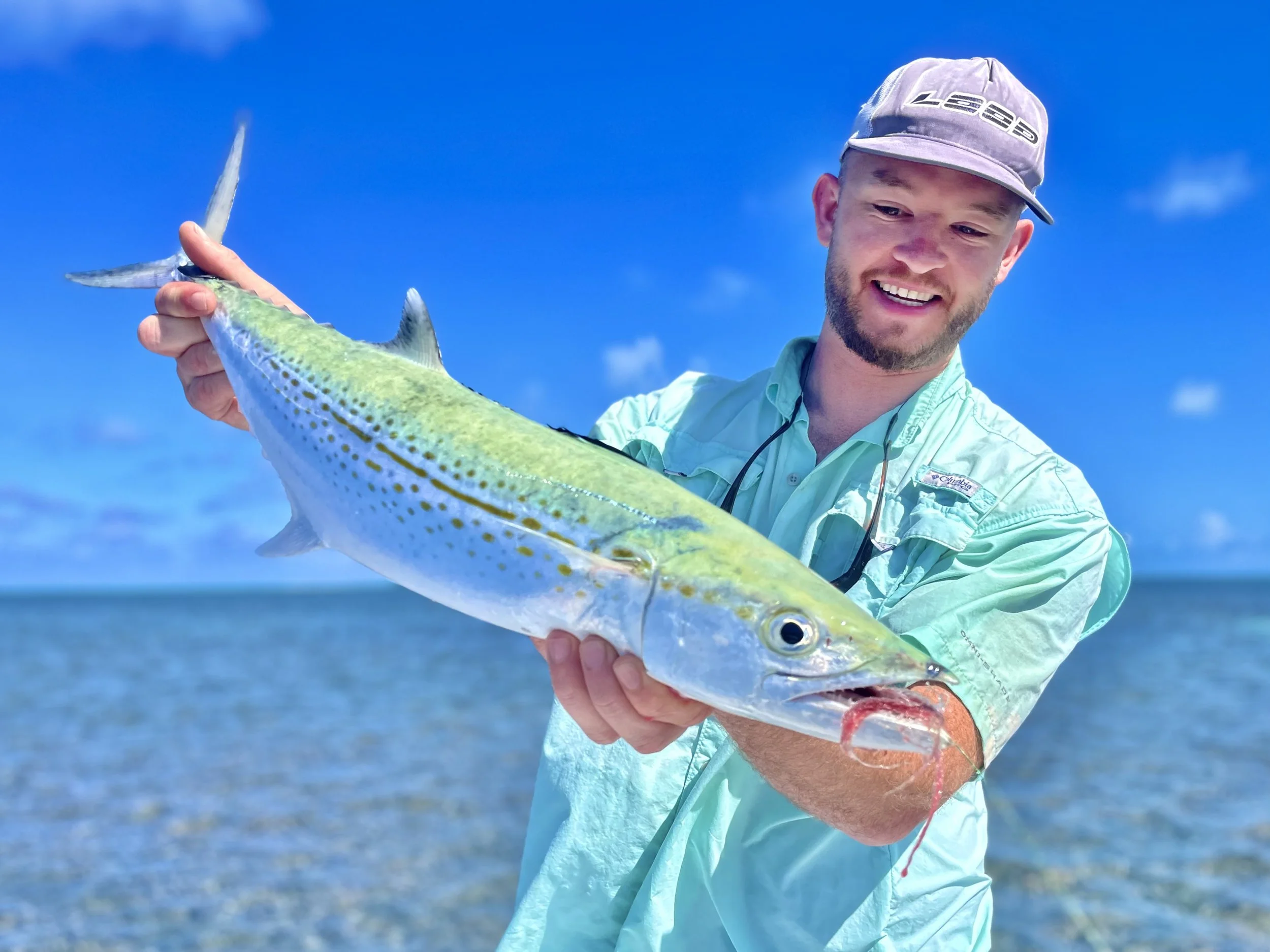 Angler holding a cero mackerel caught while fishing the waters of Grand Bahama.