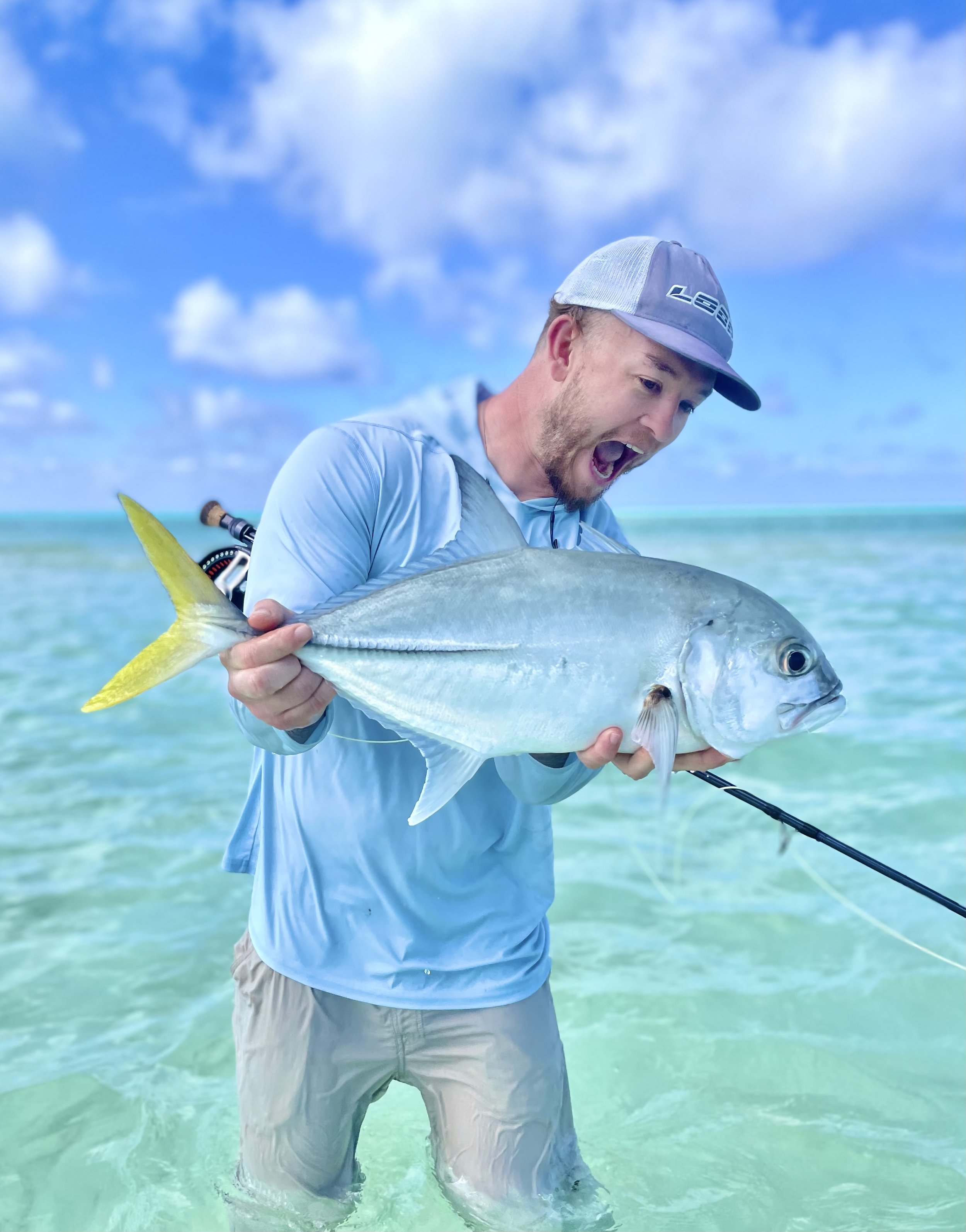 Angler holding a large horse-eye jack in the clear waters of Grand Bahama, Bahamas.