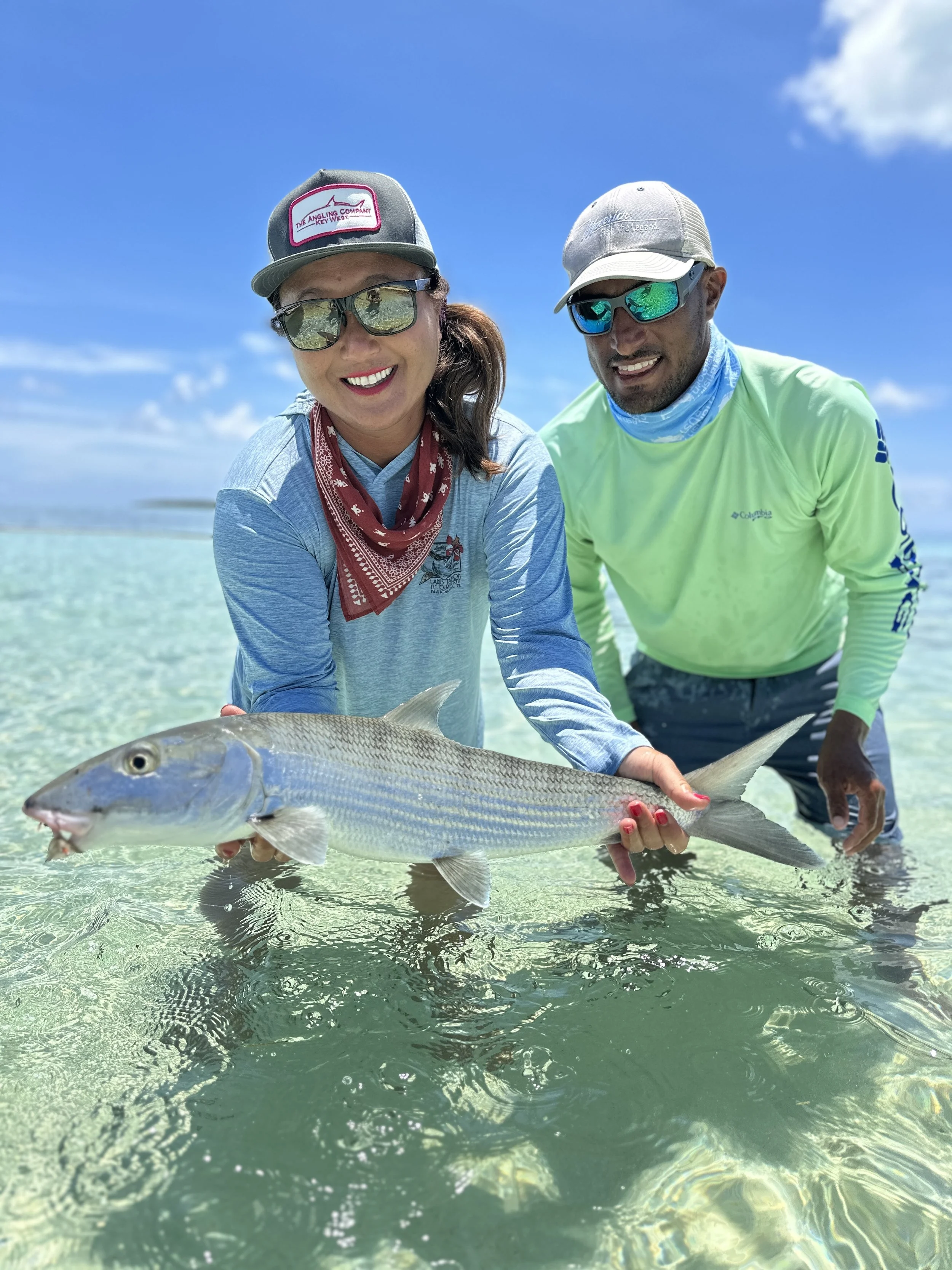 Angler and guide Justin Lewis holding a bonefish while fly fishing the clear flats of Grand Bahama.