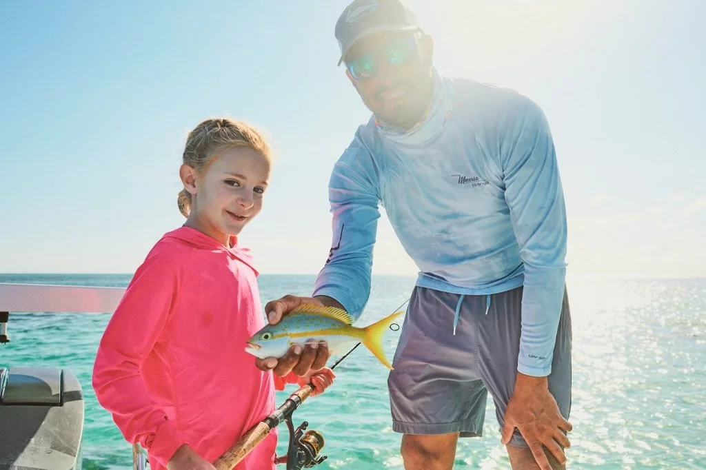 Captain Justin Lewis with young angler catching fish during a family-friendly eco-tour in Grand Bahama, Bahamas.