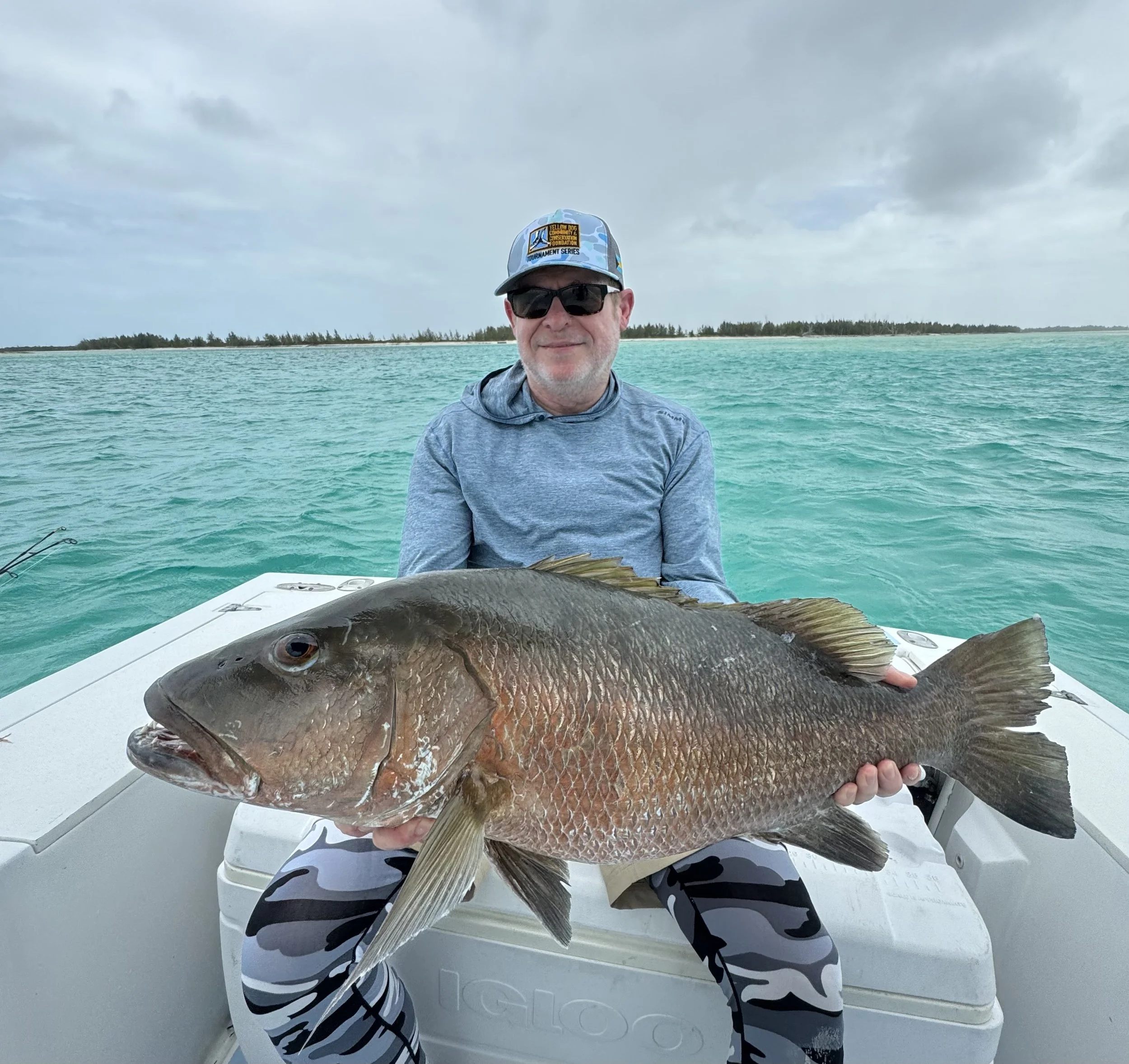 Angler holding a trophy cubera snapper caught while inshore fishing in Grand Bahama, Bahamas.