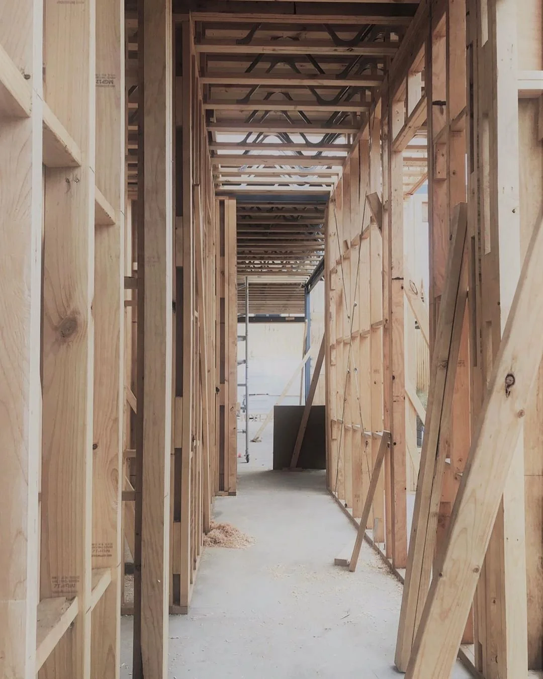 Wooden framing for a building under construction, including wall studs, ceiling joists, and supports.