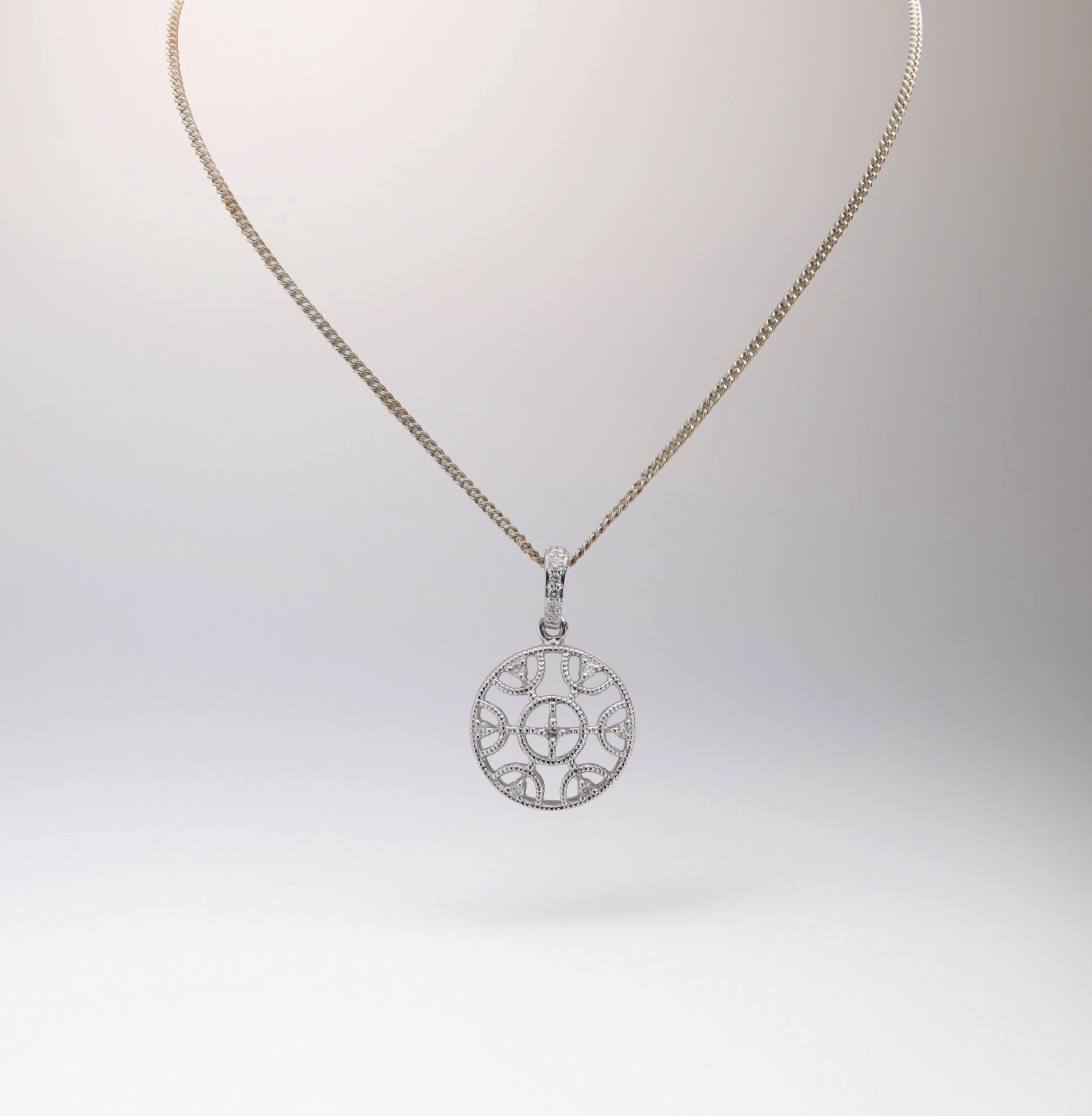 9ct White gold Circular Filagree Pendant, Set with a diamond in the centre and edges with diamond set bale