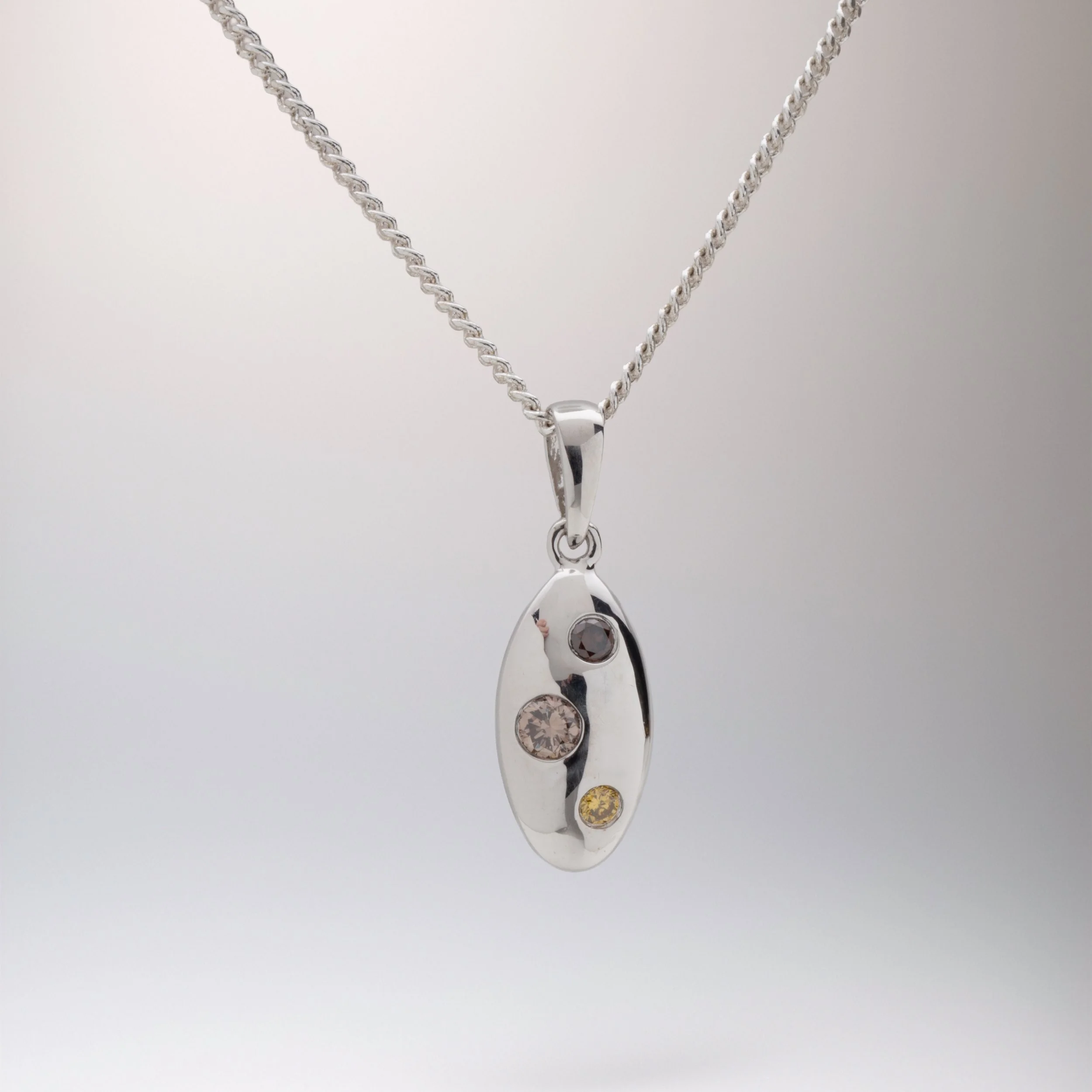 9ct White Gold oval Hammer set Pendant featuring 3 Multicoloured cognac diamonds