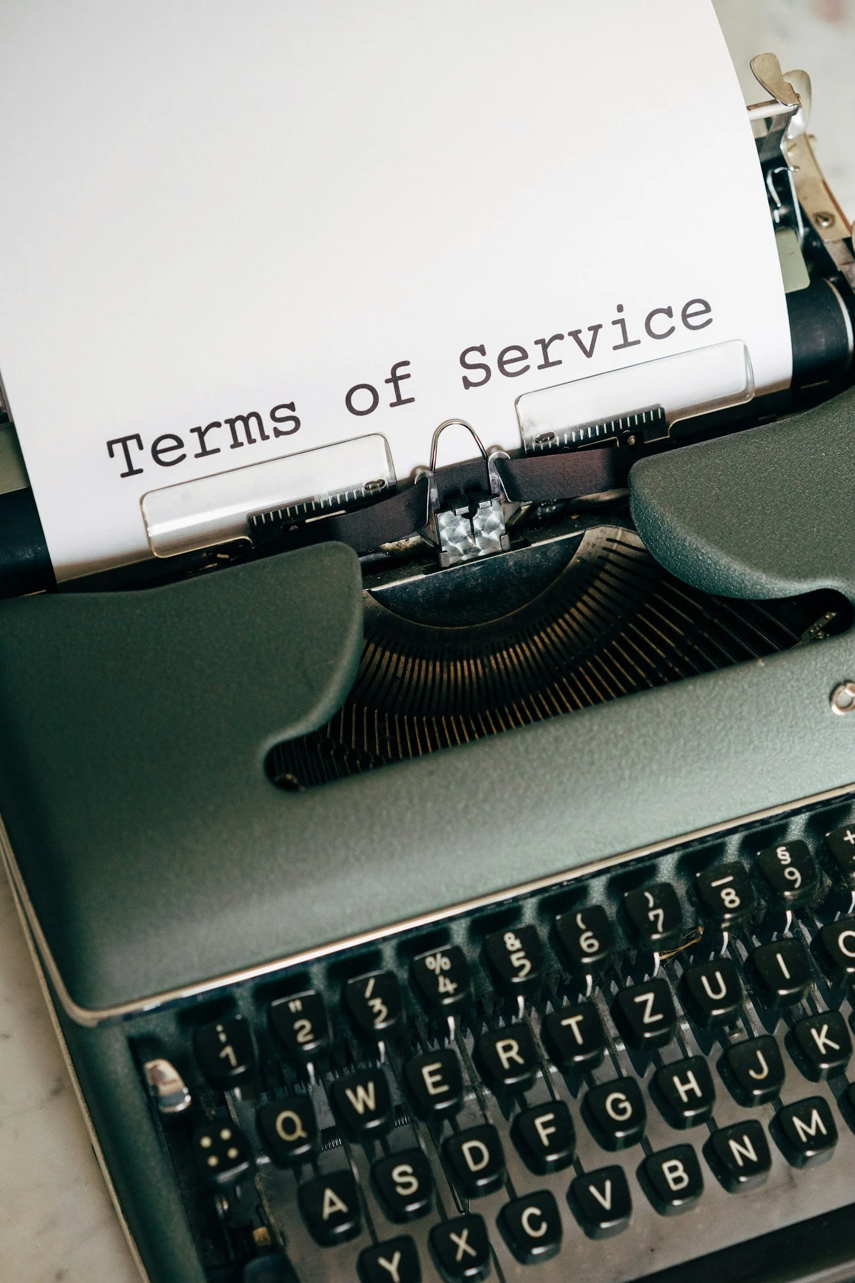 Close-up of a vintage typewriter with a paper that reads 'Terms of Service' in black type.