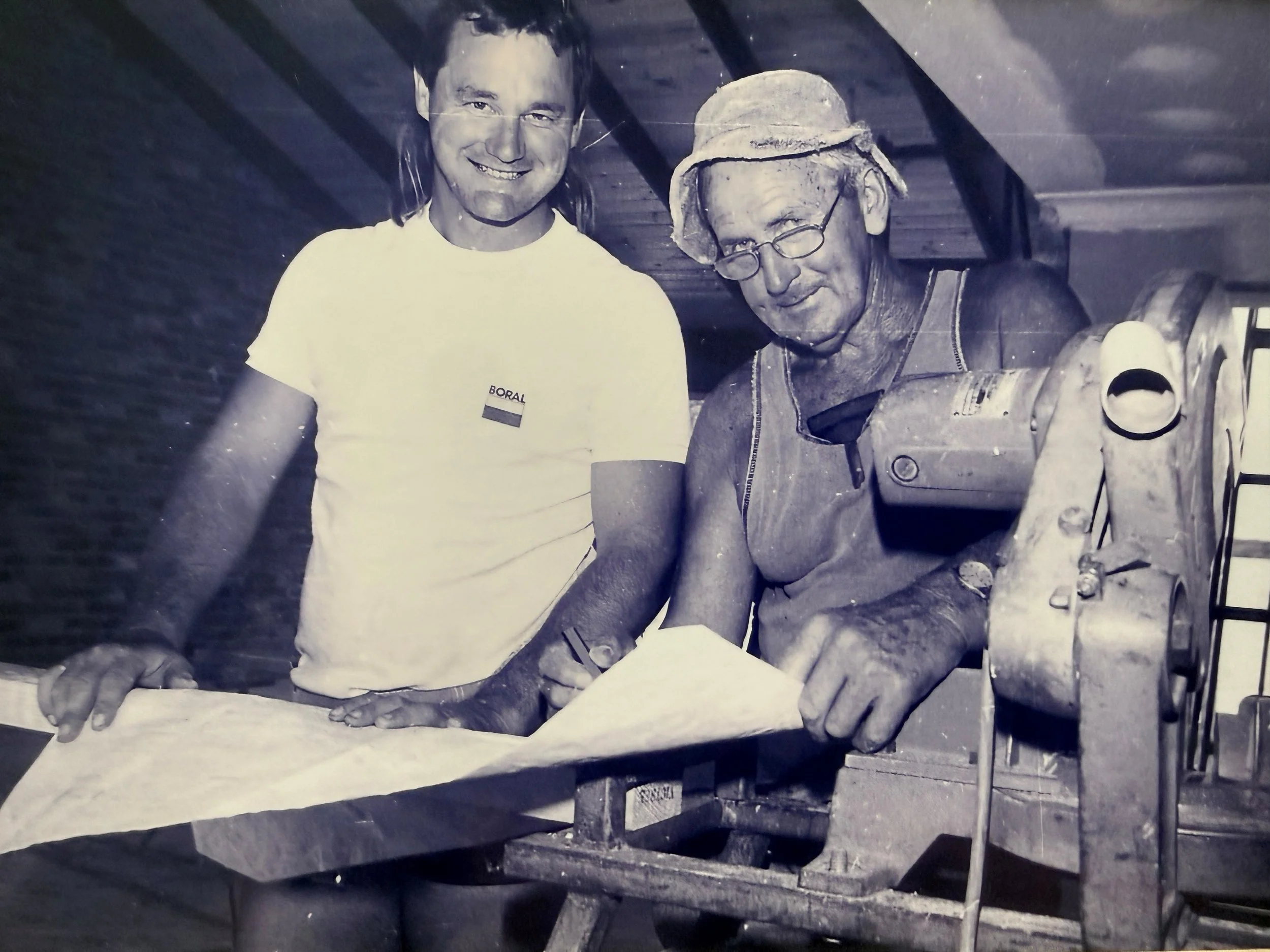 A young Jack Riches with his father Clarrie Riches reading building plans, working on site.