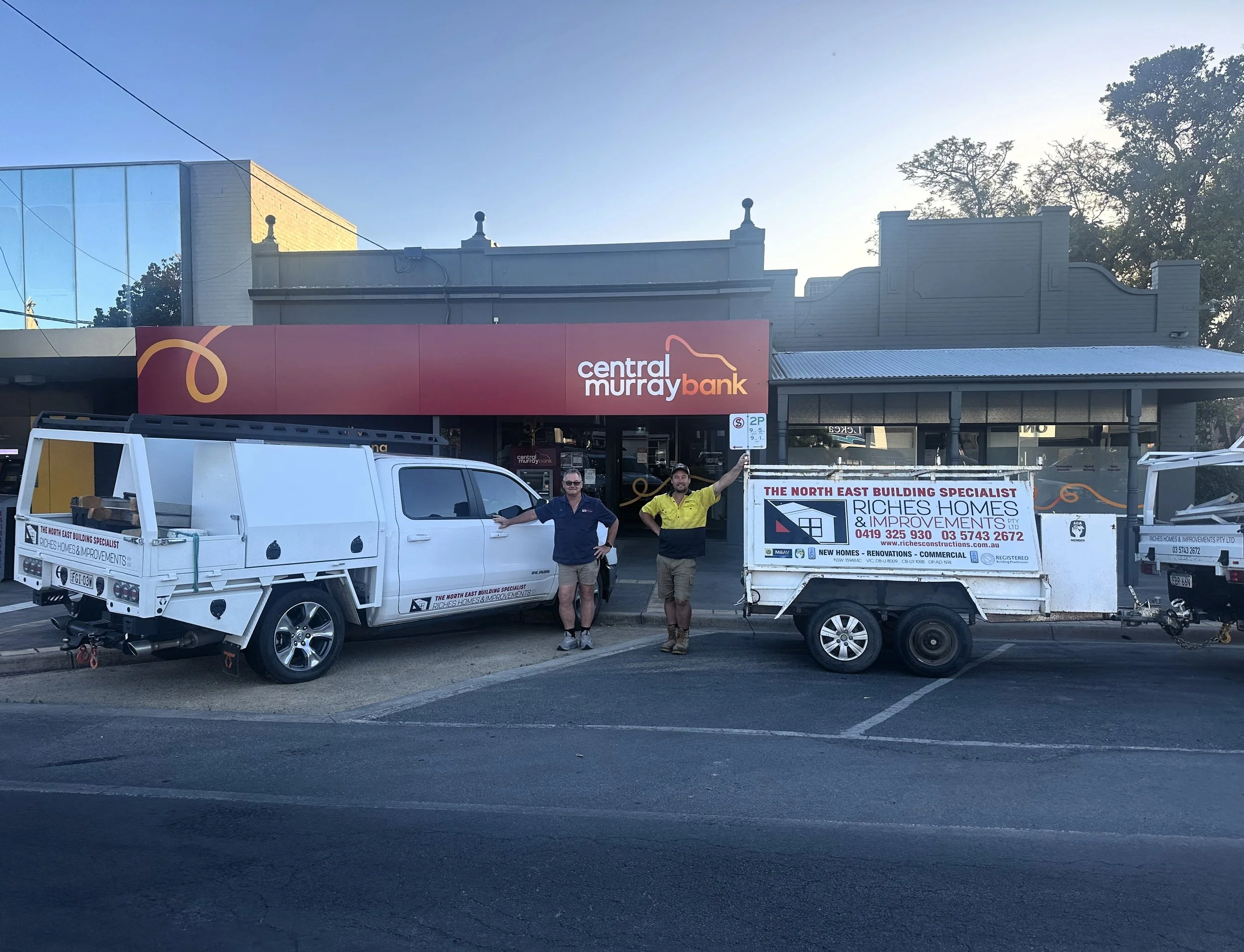 Jack and Josh Riches stand in front of their company vehicles with signage that reads 'Riches Homes & Improvements' parked in front of 'Central Murray Bank' in Belmore St Yarrawonga Victoria.