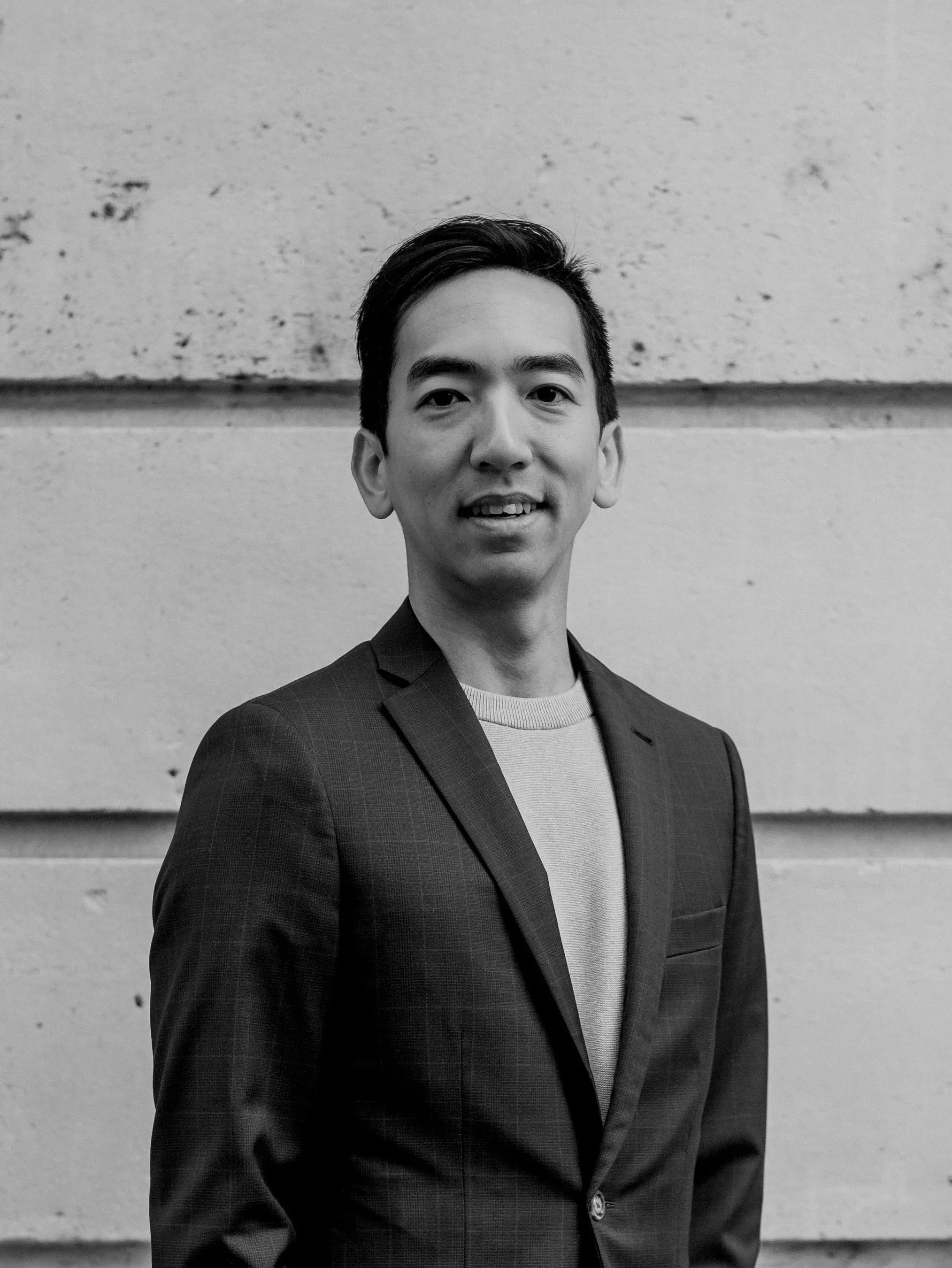 Portrait of Dr. Justin Cheng, Honolulu plastic surgeon, wearing a suit jacket outdoors.