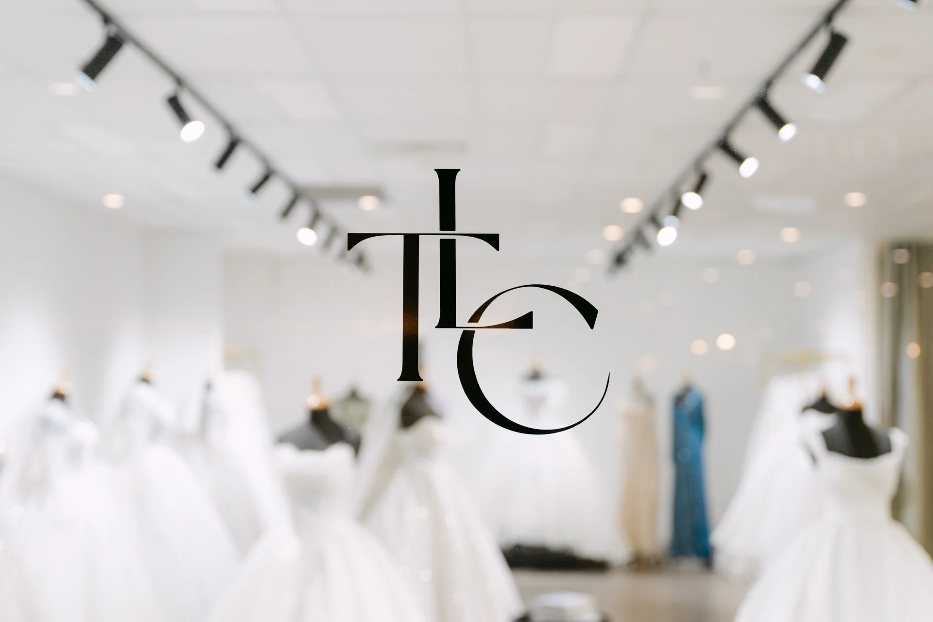 Fashion boutique with wedding dresses on mannequins, and the text 'I T C' in the foreground.