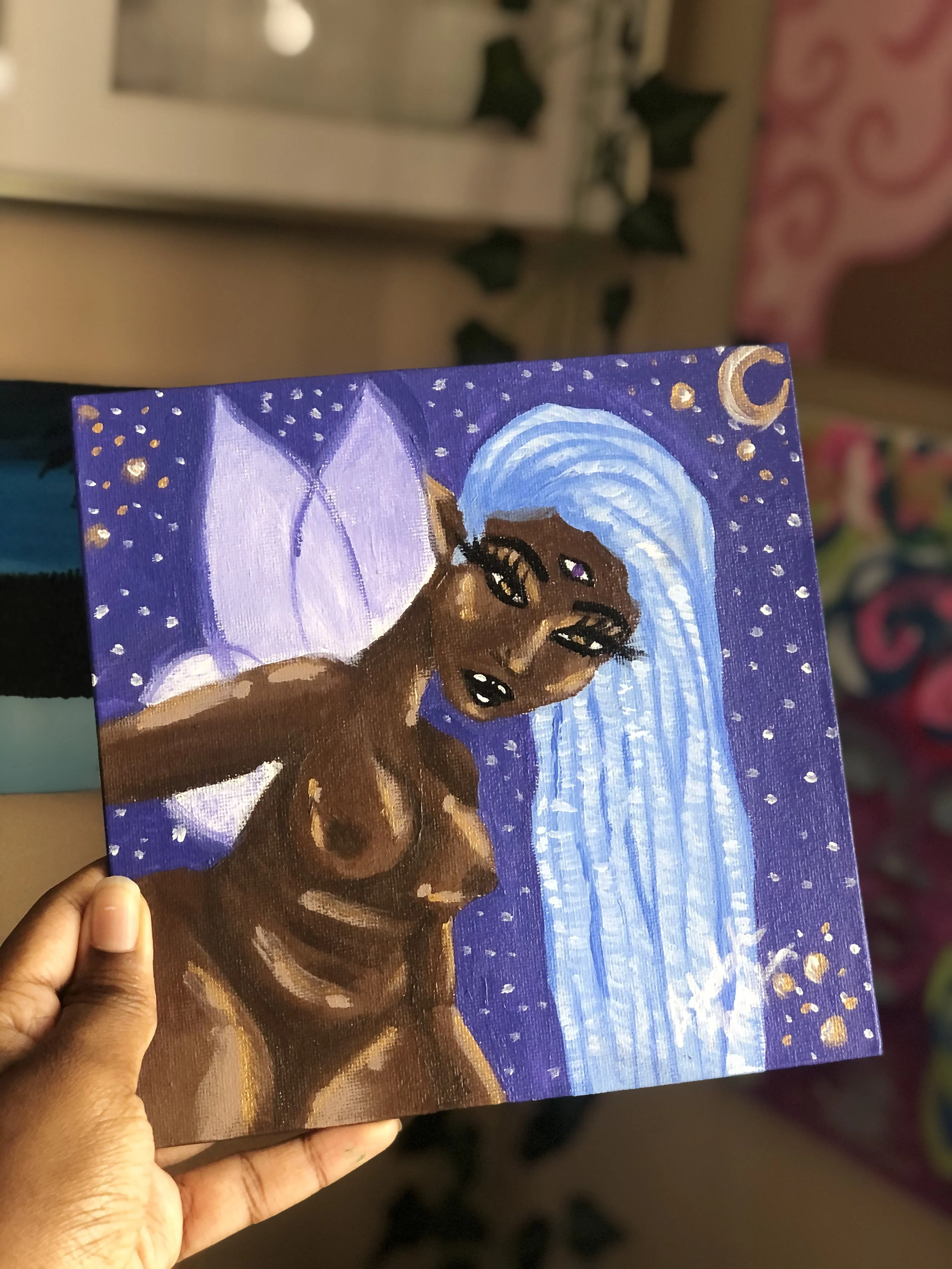 A painting of a dark-skinned fairy with long blue hair, purple wings, and a purple unicorn horn, set against a starry night sky with a crescent moon.