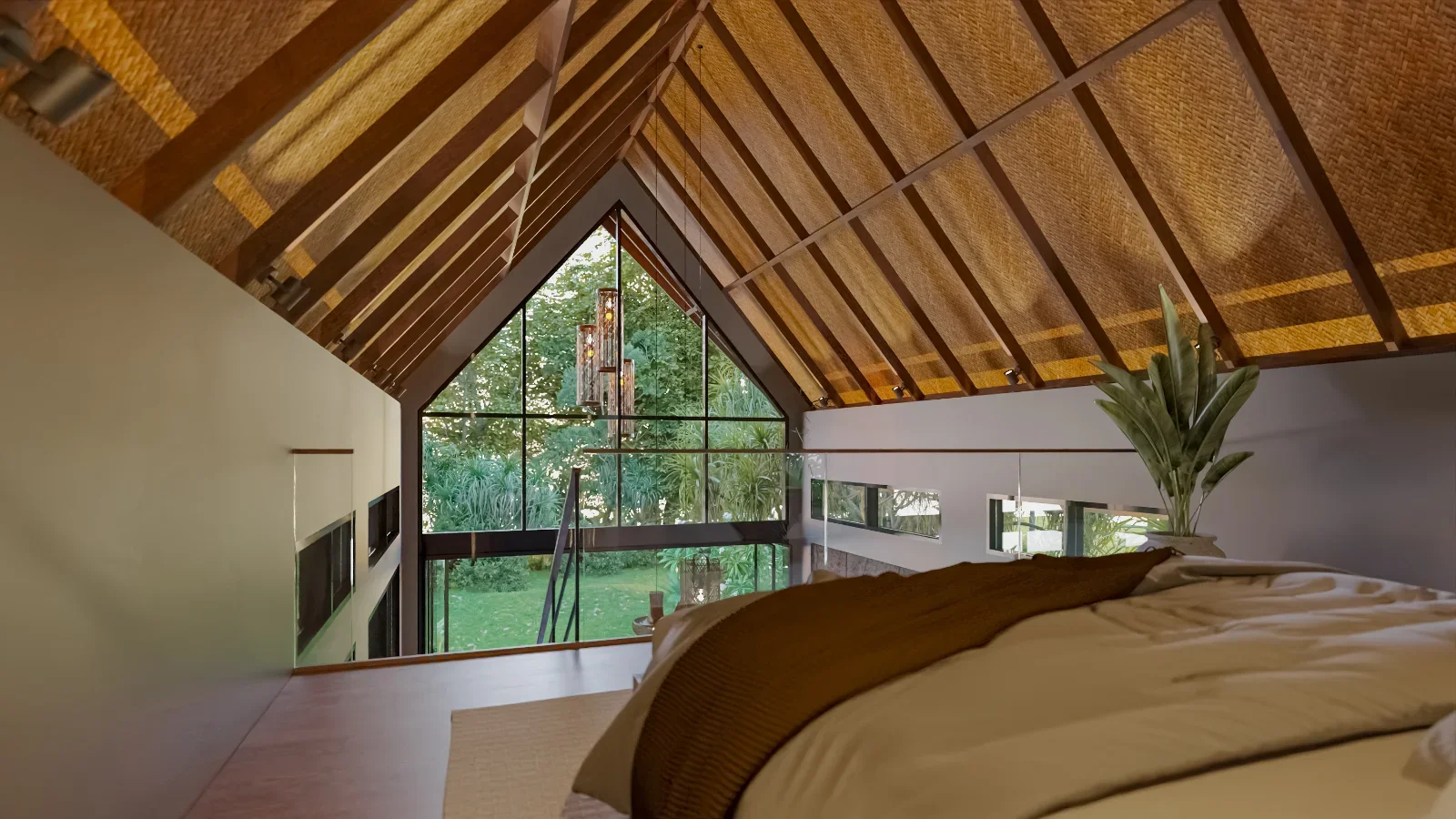 View from a bedroom loft with a sloped wooden ceiling, large windows showing a green garden, a kitchen under the loft, and a bed with white and brown bedding.