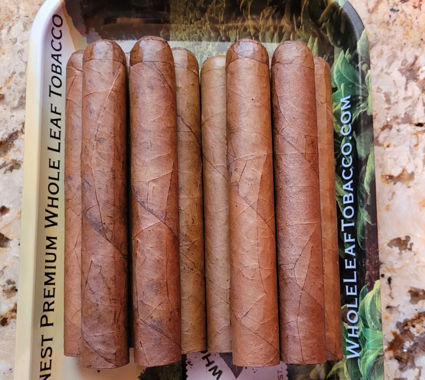 rolled cigars fresh on a tray.png