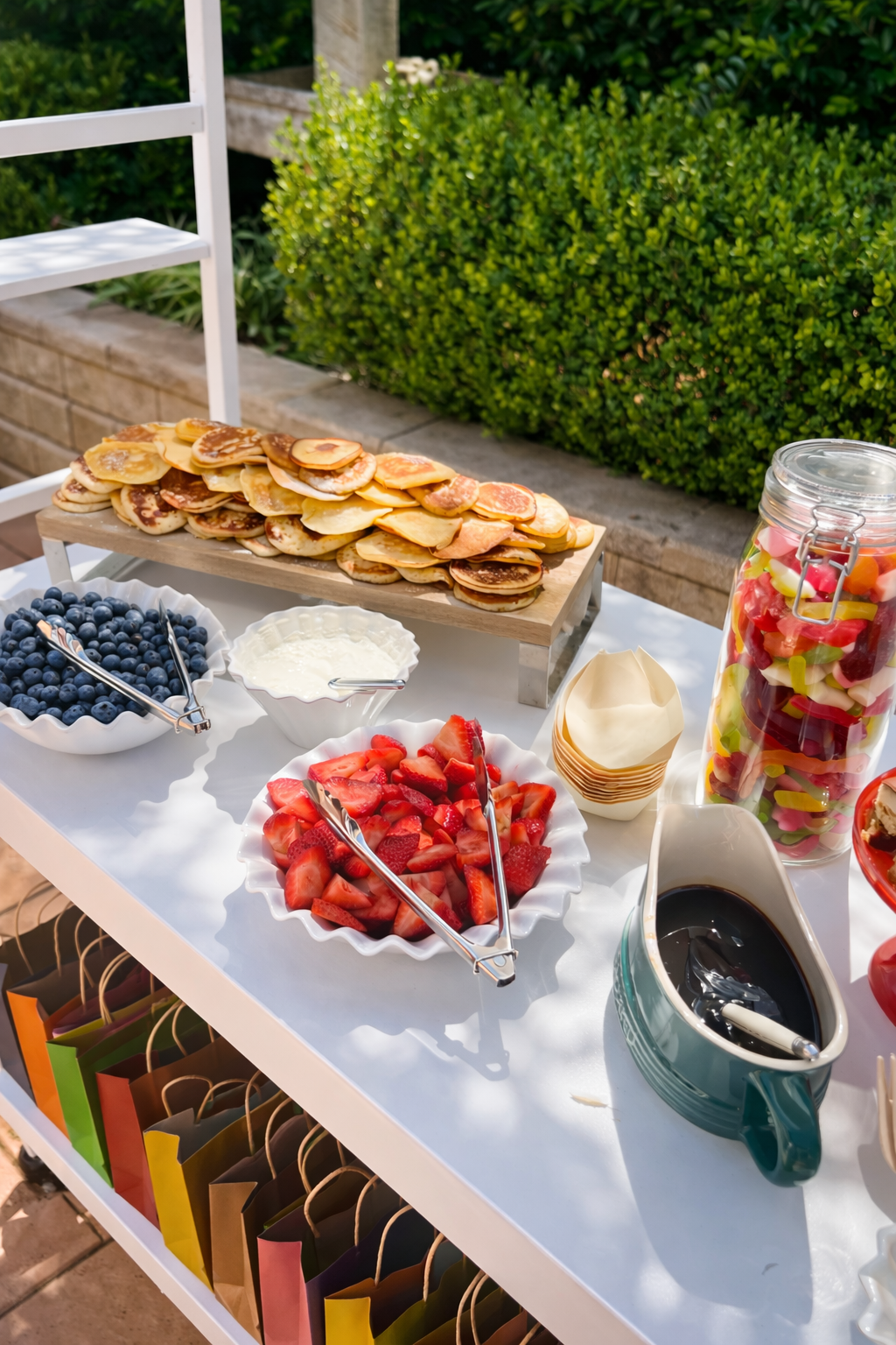 Pancake breakfast catering setup with fresh fruit and toppings by 10 Pounds, served with a coffee cart at an outdoor event.