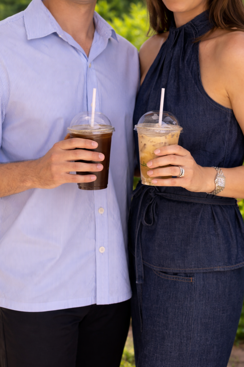Guests holding iced coffee drinks served by 10 Pounds at an outdoor event.