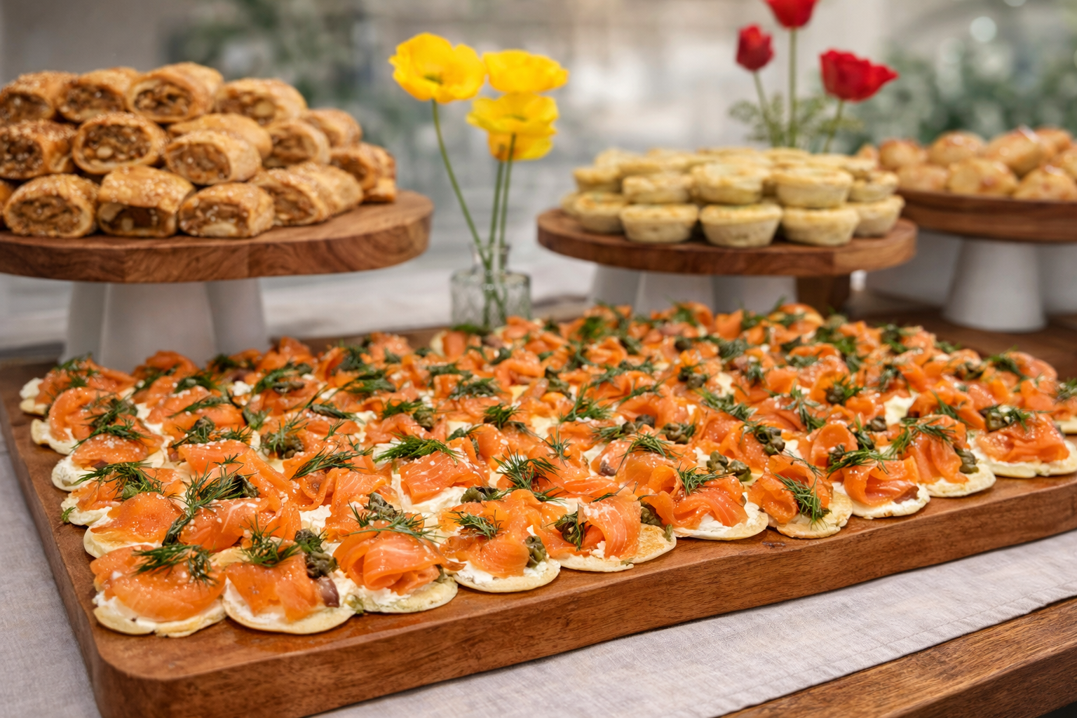 Assorted finger food platters including smoked salmon blinis and savoury pastries and salmon blinis by 10 Pounds catering.