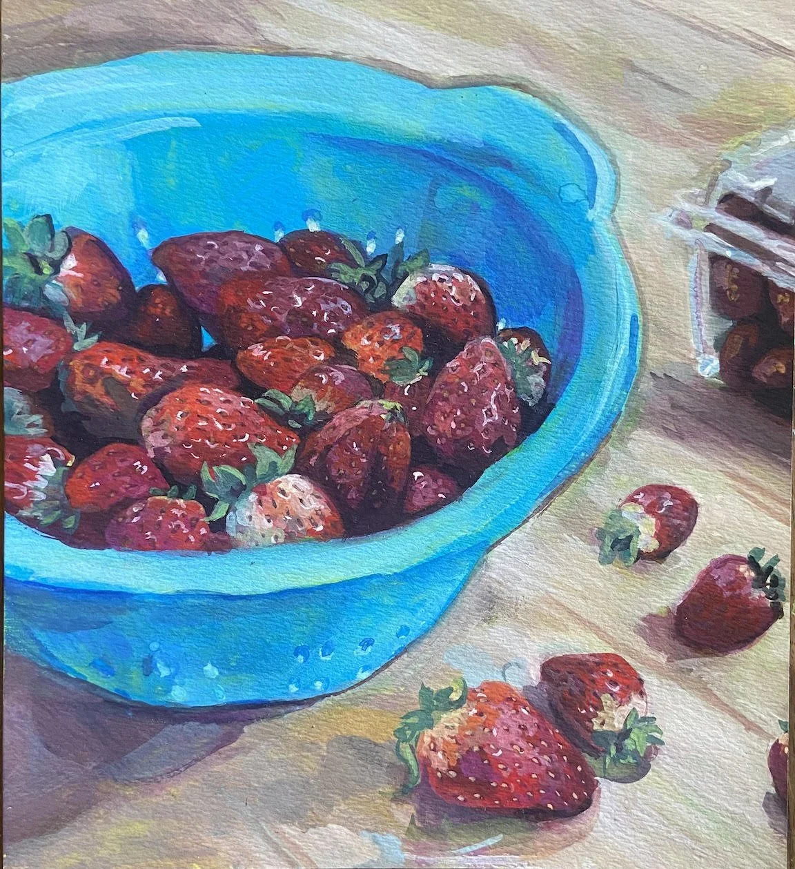 Gouache painting of a blue plastic colander filled with strawberries on a wooden table. There's some strawberries scattered on the table and the corner of the berry container peaking in on the right.