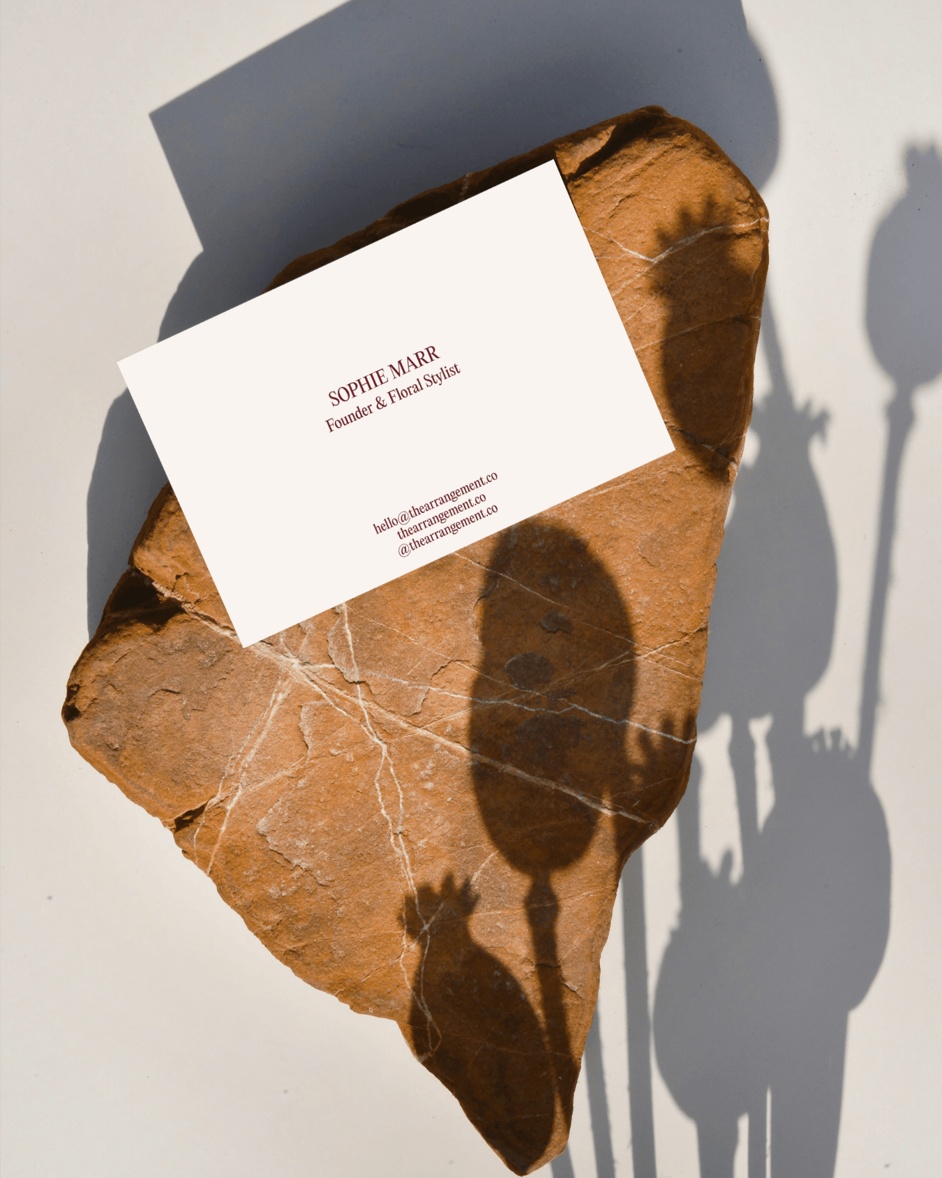 Reverse side of a luxury business card detailing contact information for a sculptural floral studio. Elegant typography and refined print layout.