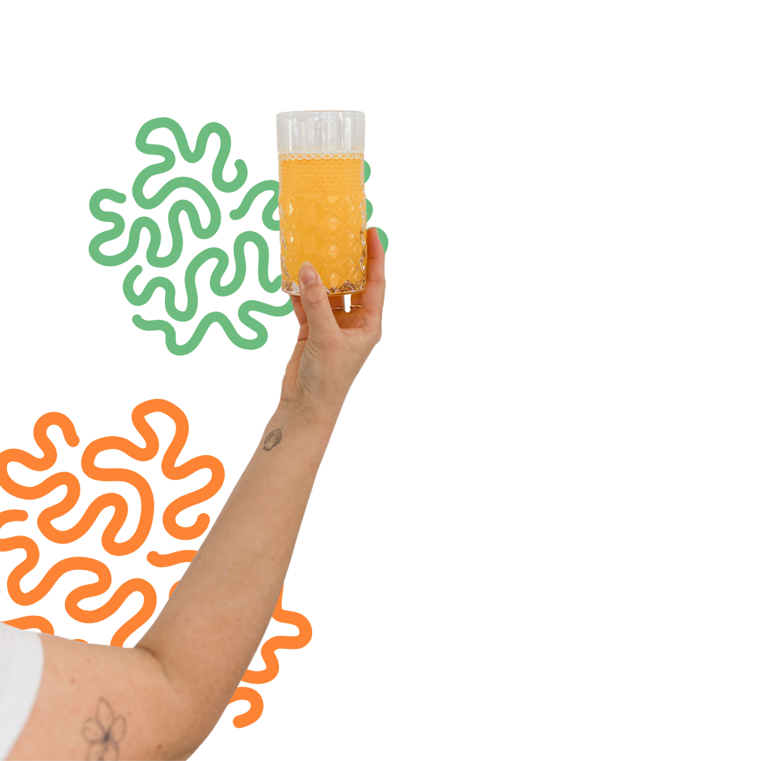 A person's hand holding a glass of orange juice with a textured pattern, against a colorful, abstract background.