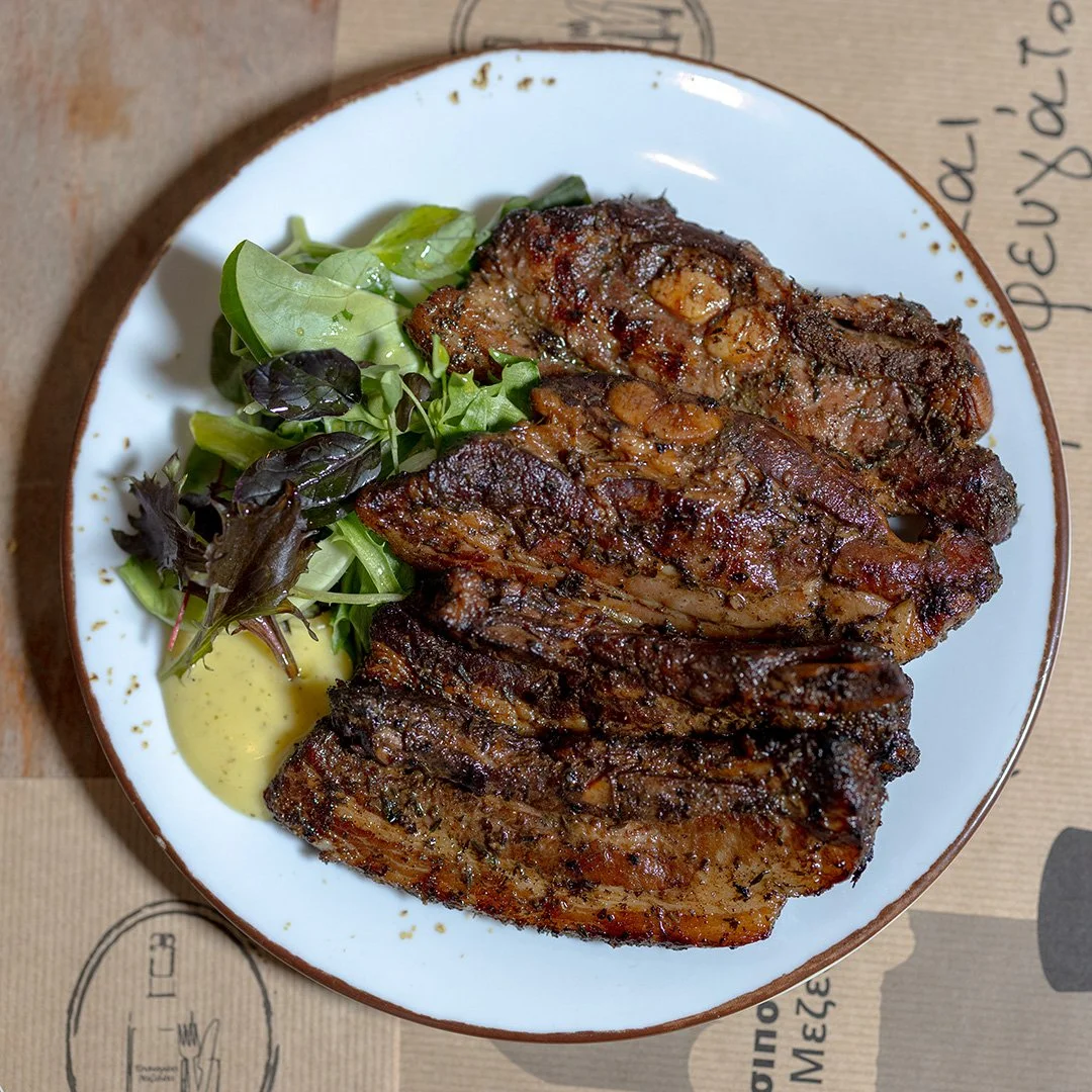 Grilled beef ribs served with mixed greens salad and green spicy sauce.