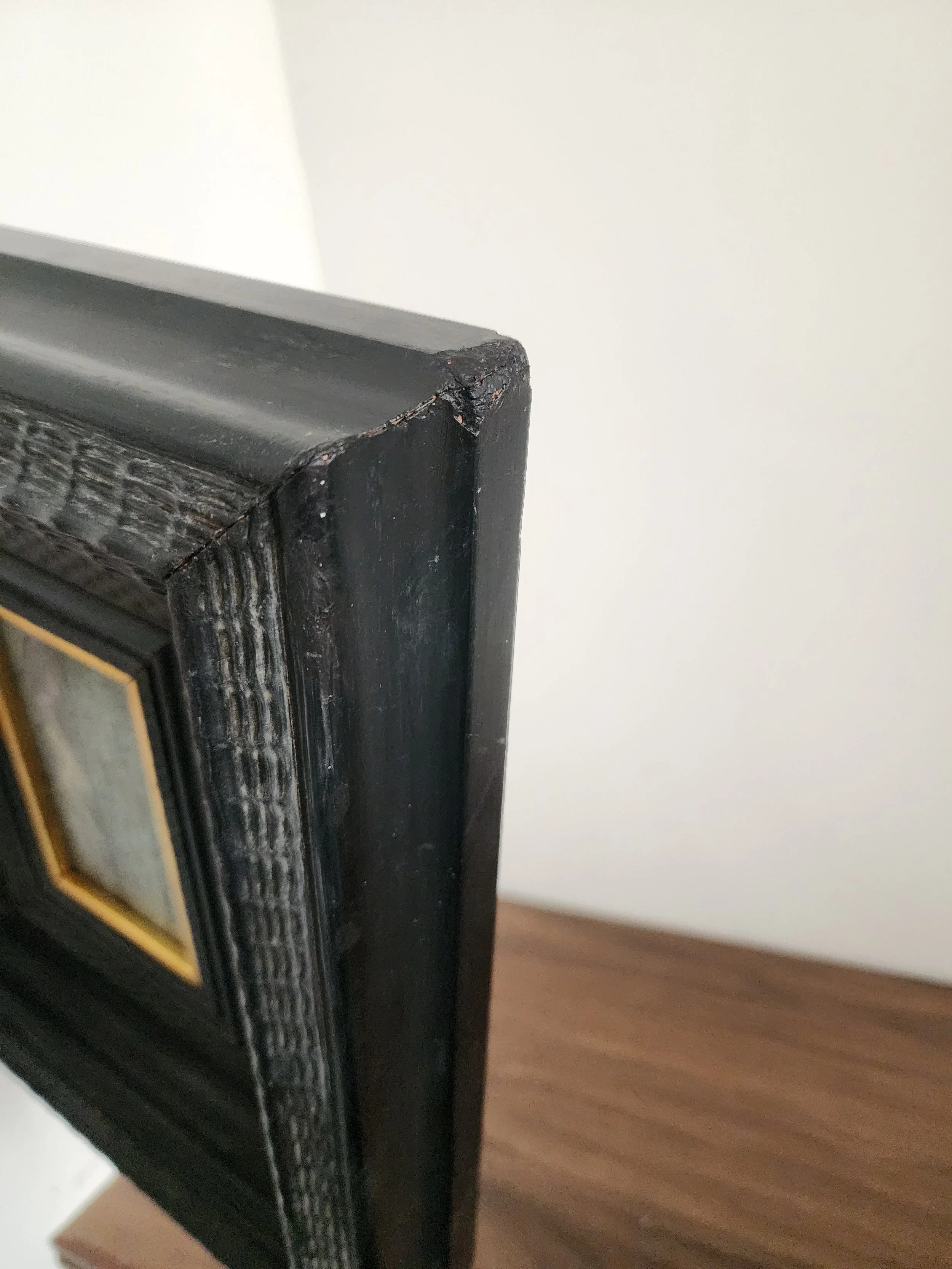 Close-up of vintage seascape oil painting with gold accent.