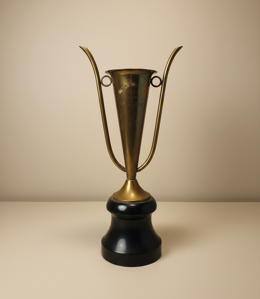 vintage brass trophy cup with sculptural handles on wooden base
