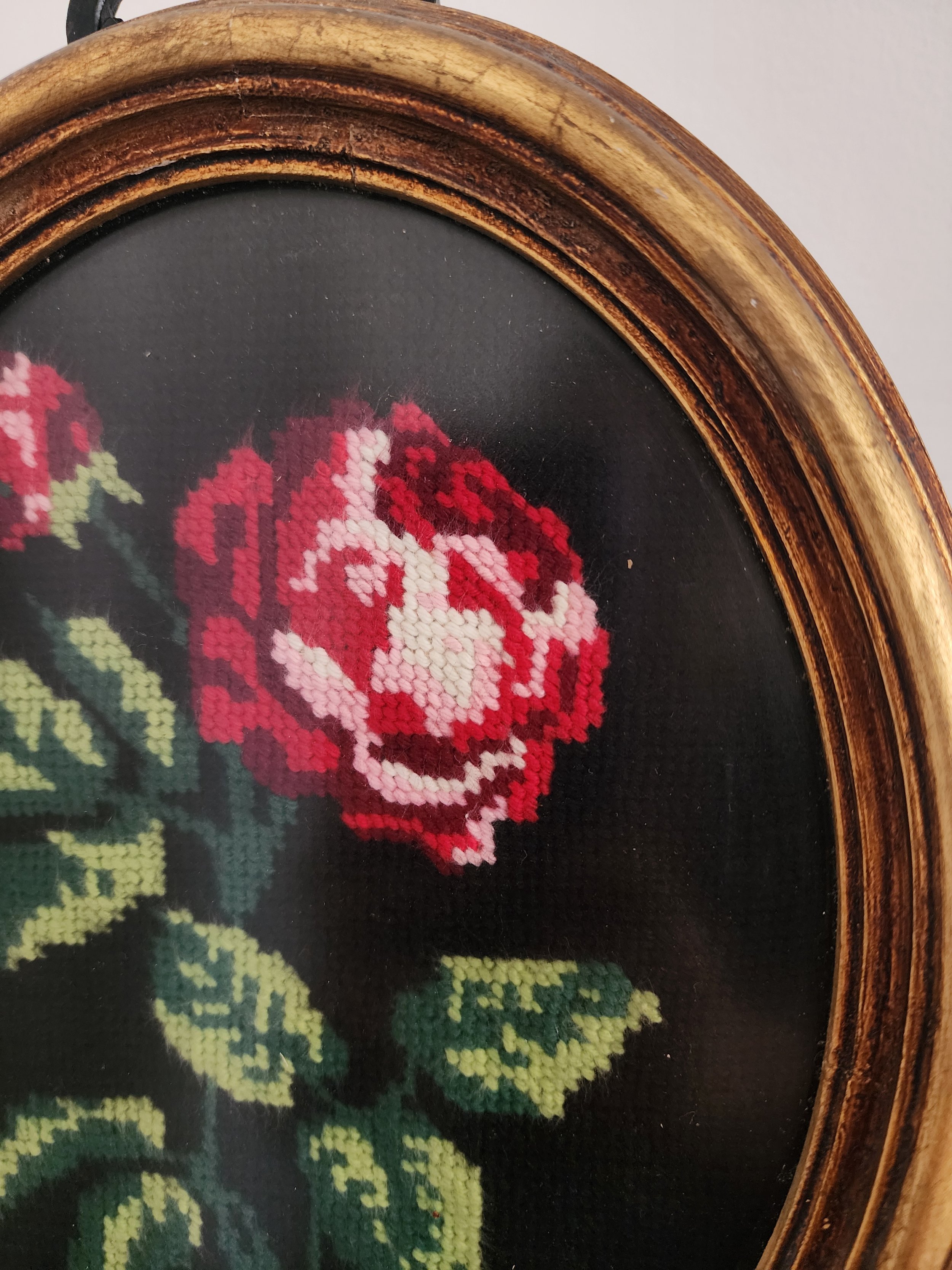 Close-up of needlepoint rose artwork in gold frame.jpg