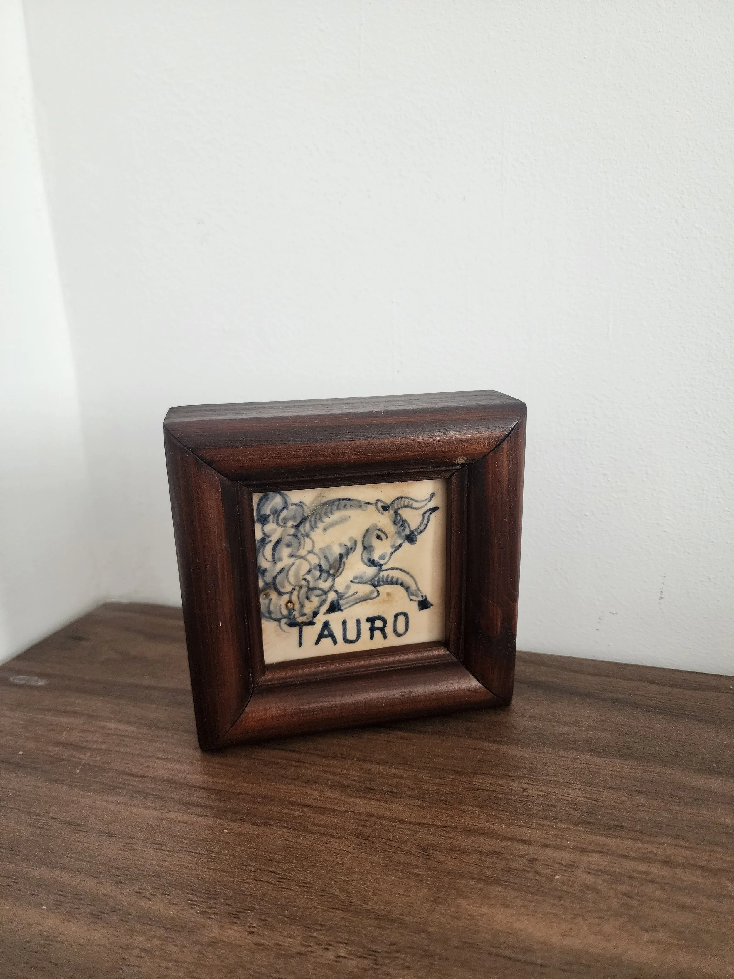 Hand-painted “Tauro” tile with blue bull on cream background.